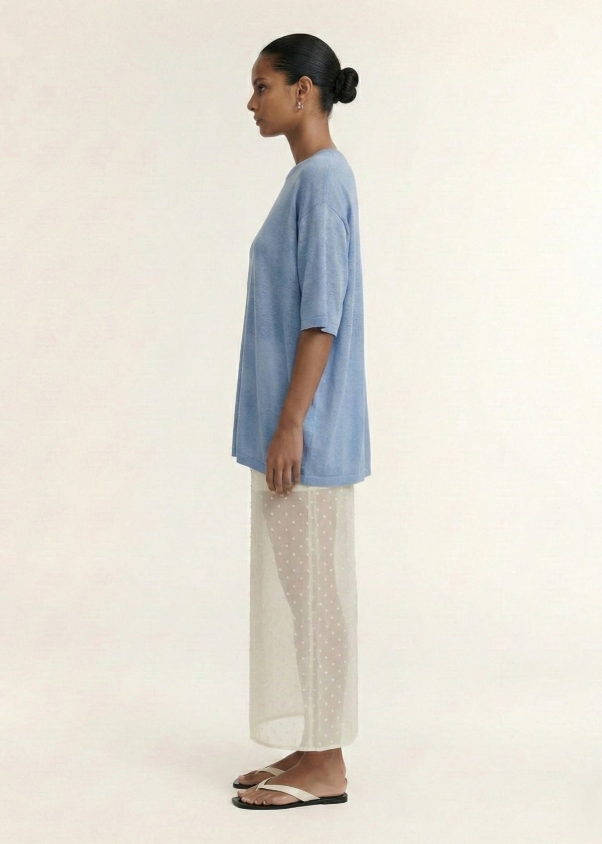 Side view of the Blue Round Neck Oversized Knit Tee, showing a lightweight knit fabrication and a round neckline.