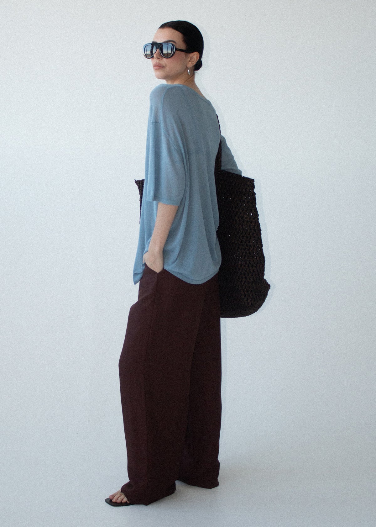 Side profile of the Blue Round Neck Oversized Knit Tee with dropped shoulders and elbow-length sleeves.