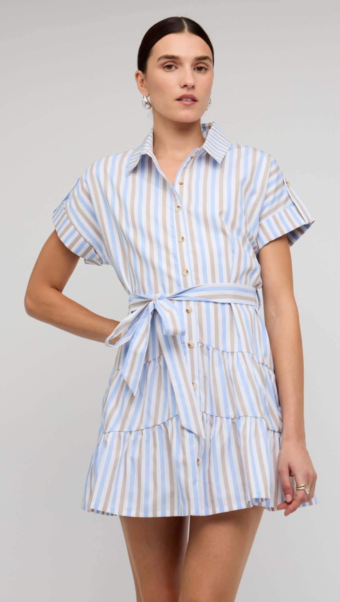Blue Stripe Cotton Mini Shirt Dress worn by a model, showcasing its button-down front and tie waist design.
