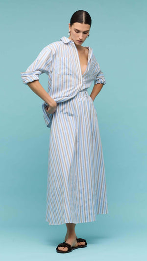 Model wearing a Blue Stripe Cotton Oversize Shirt with matching striped skirt on a blue background.