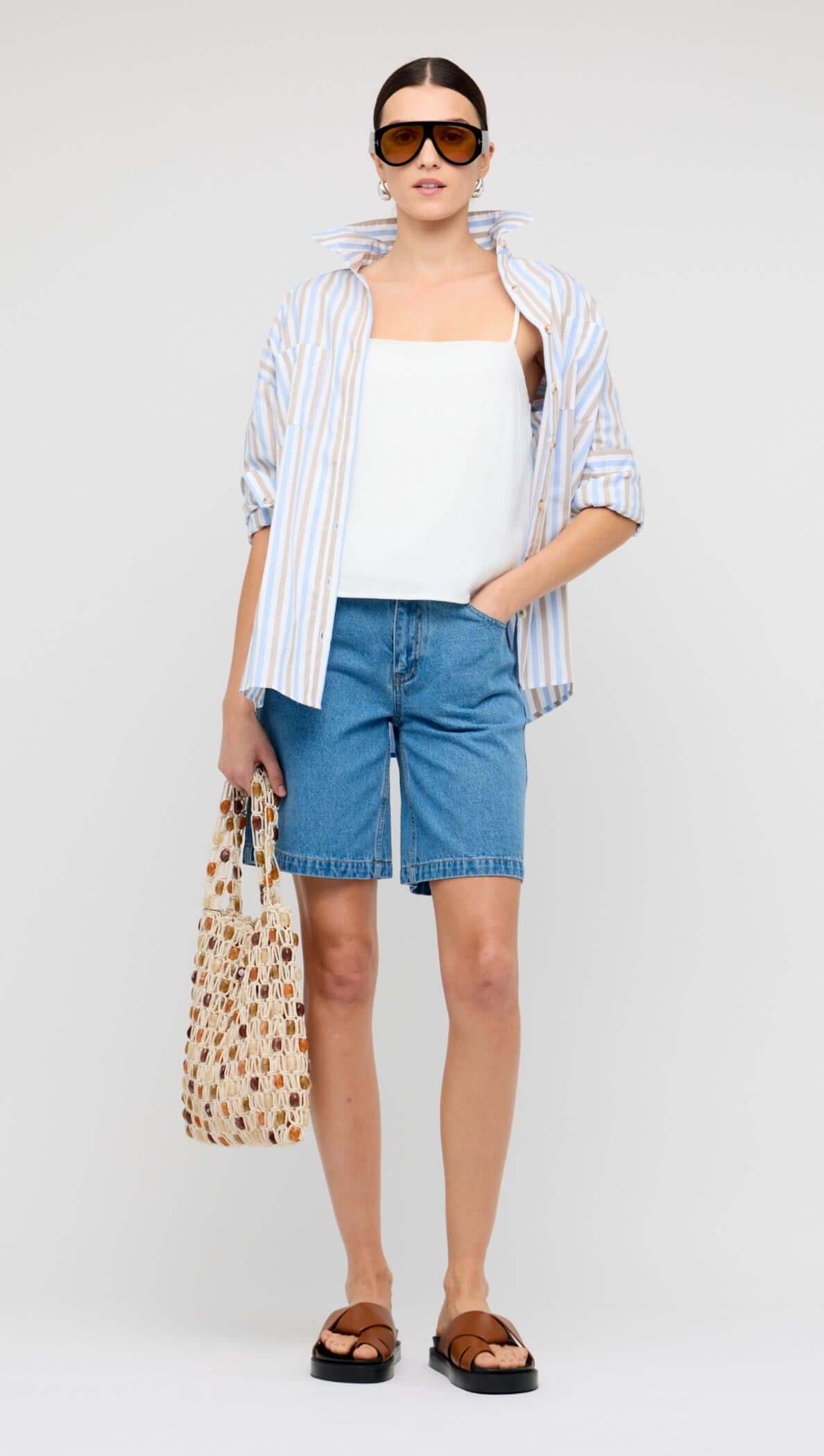 Model wearing a Blue Stripe Cotton Oversize Shirt paired with a matching skirt against a teal background.