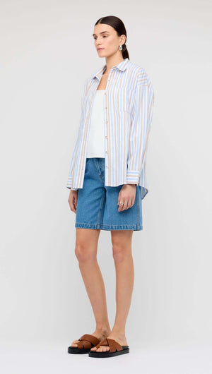 Model wearing a Blue Stripe Cotton Oversize Shirt with denim shorts and sandals.