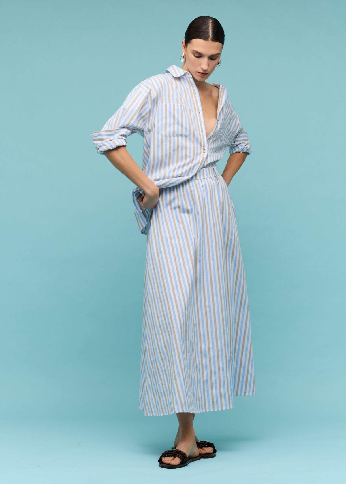 Model wearing Blue Stripe Cotton Oversize Shirt, showing a relaxed oversized fit, photographed against a teal backdrop.