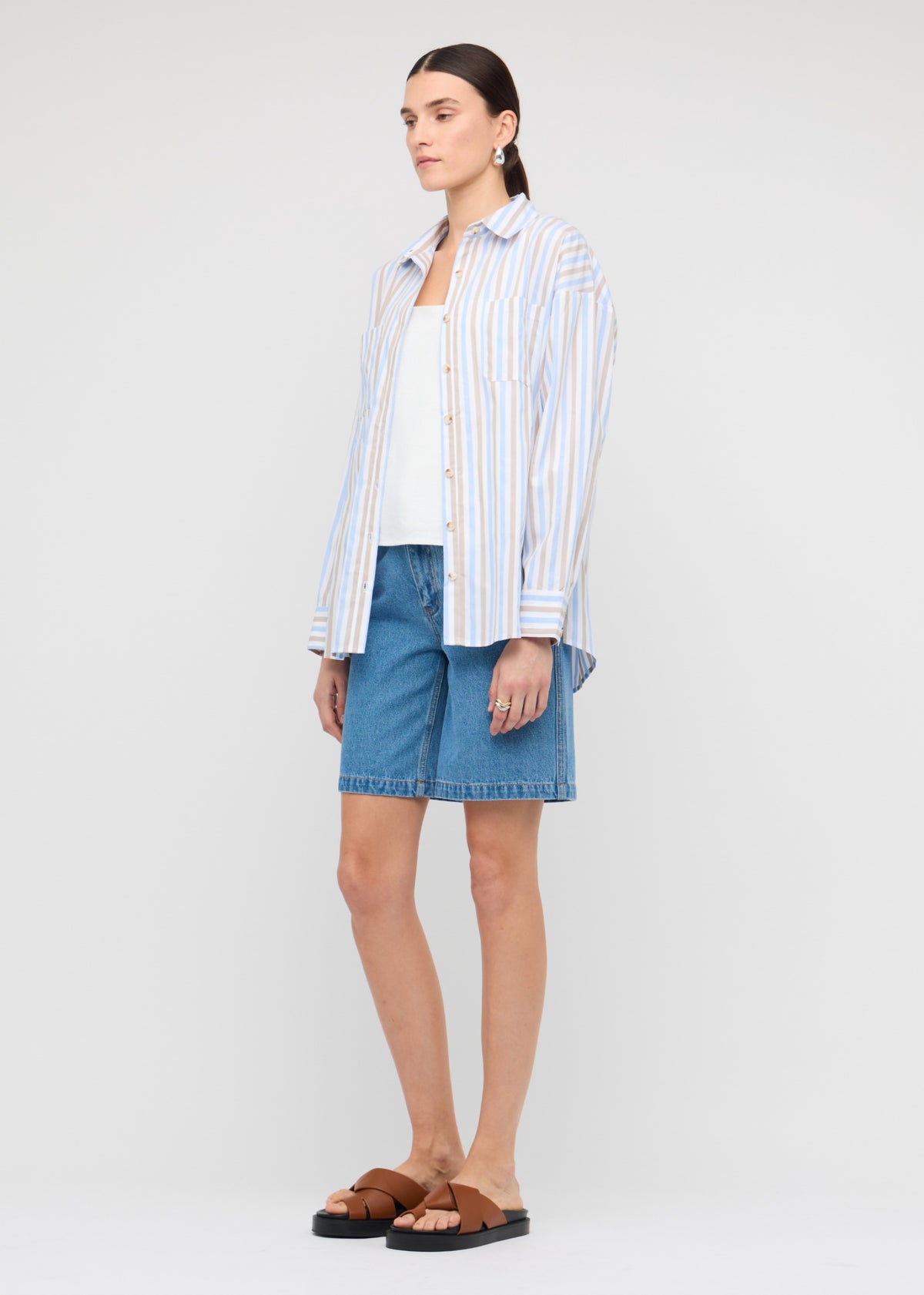 Model wearing Blue Stripe Cotton Oversize Shirt with a relaxed oversized fit (front angled).