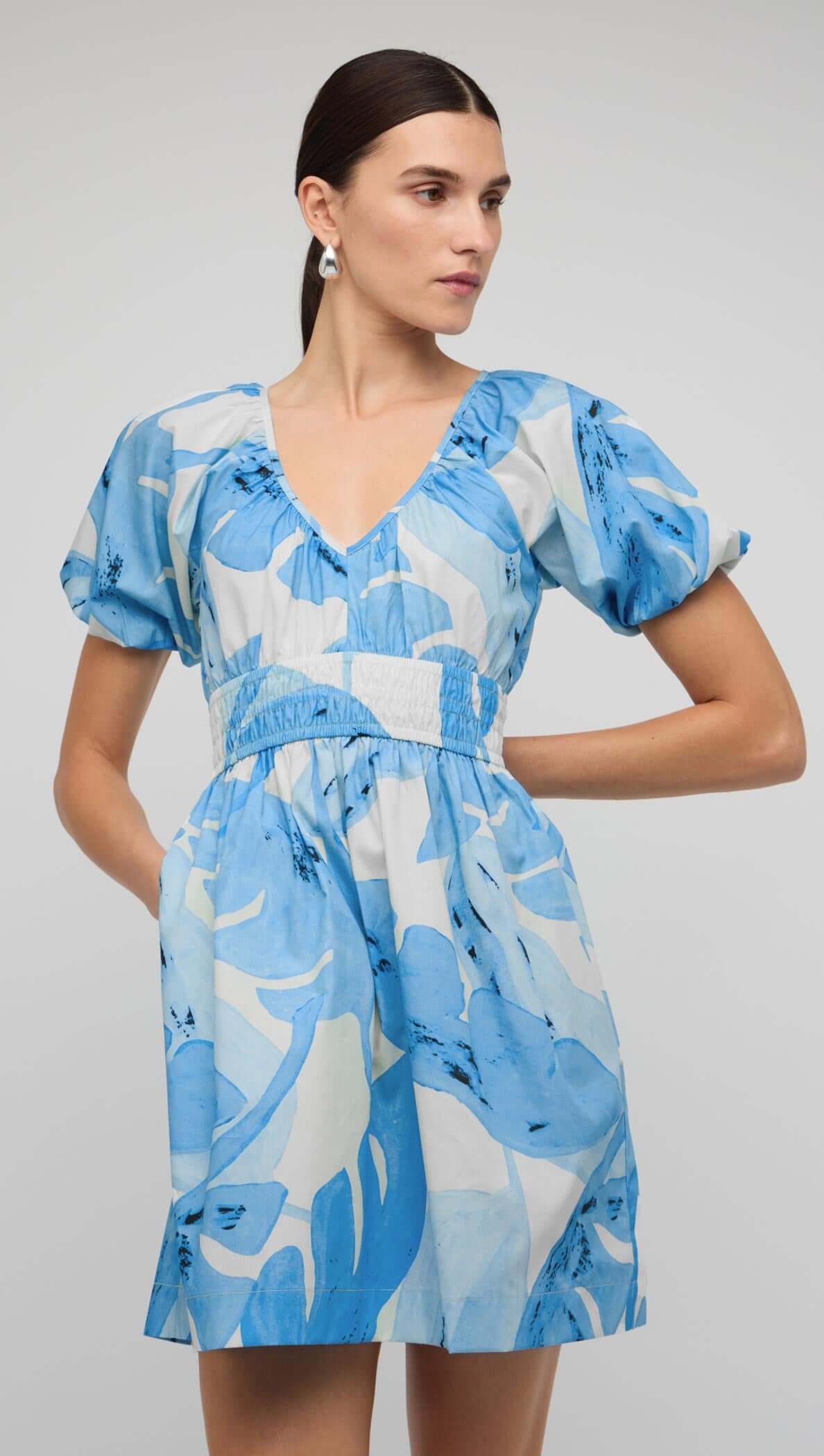 Blue & White Floral Cotton V-Neck Mini Dress worn by model with puff sleeves and shirred waistband.