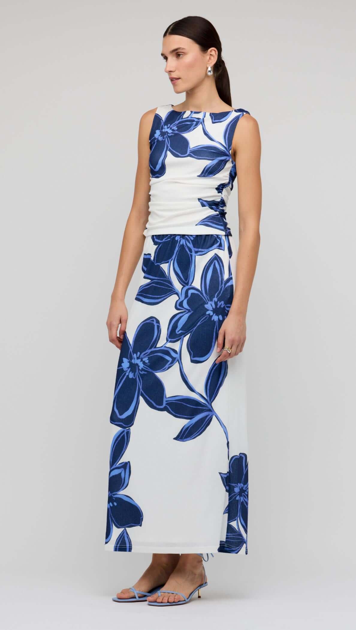 Model wearing a Blue & White Floral Mesh Maxi Skirt with a matching top, showcasing a bold floral print.
