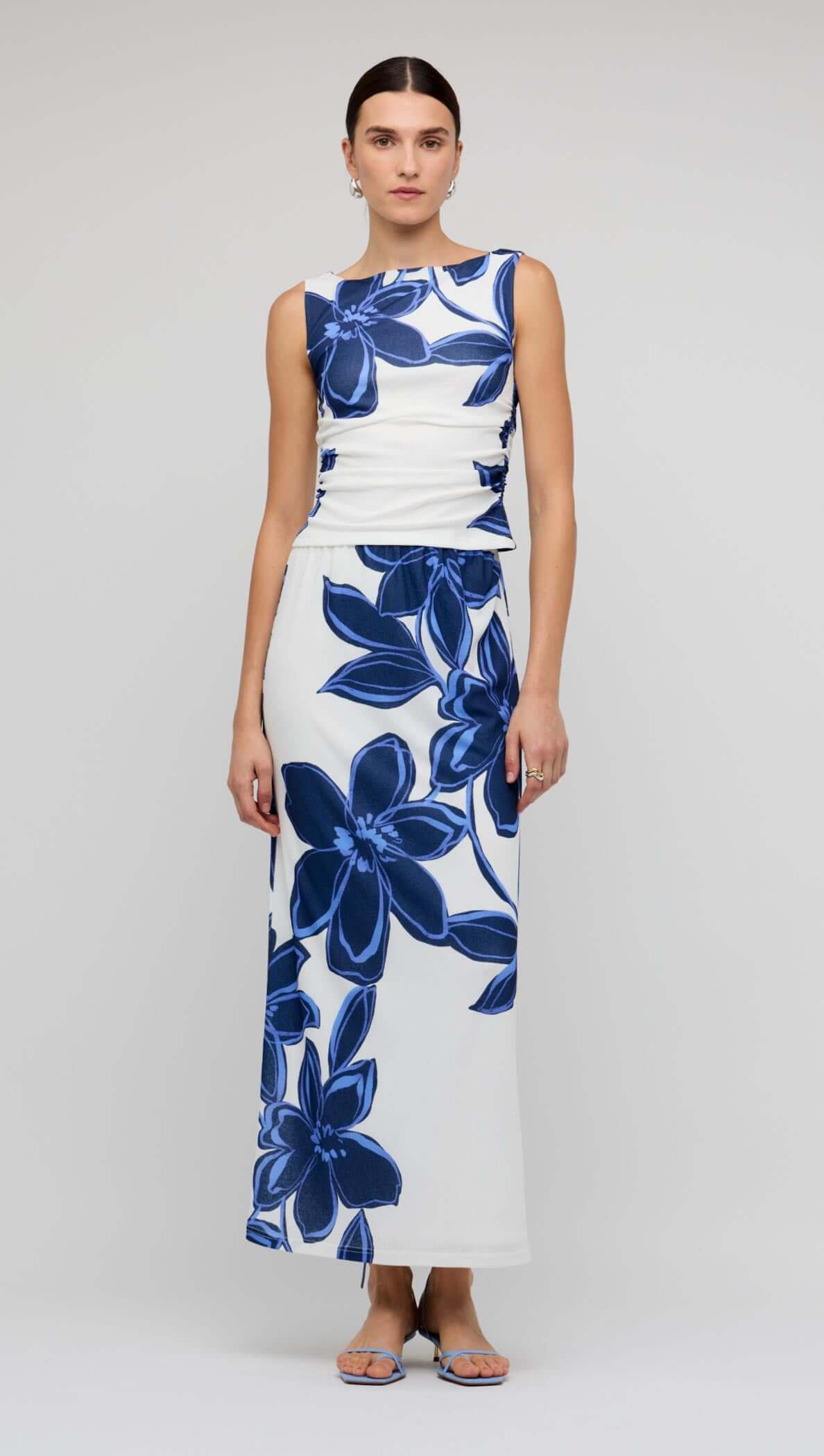 Model wearing a Blue & White Floral Mesh Maxi Skirt with a matching top, showcasing a bold floral print.