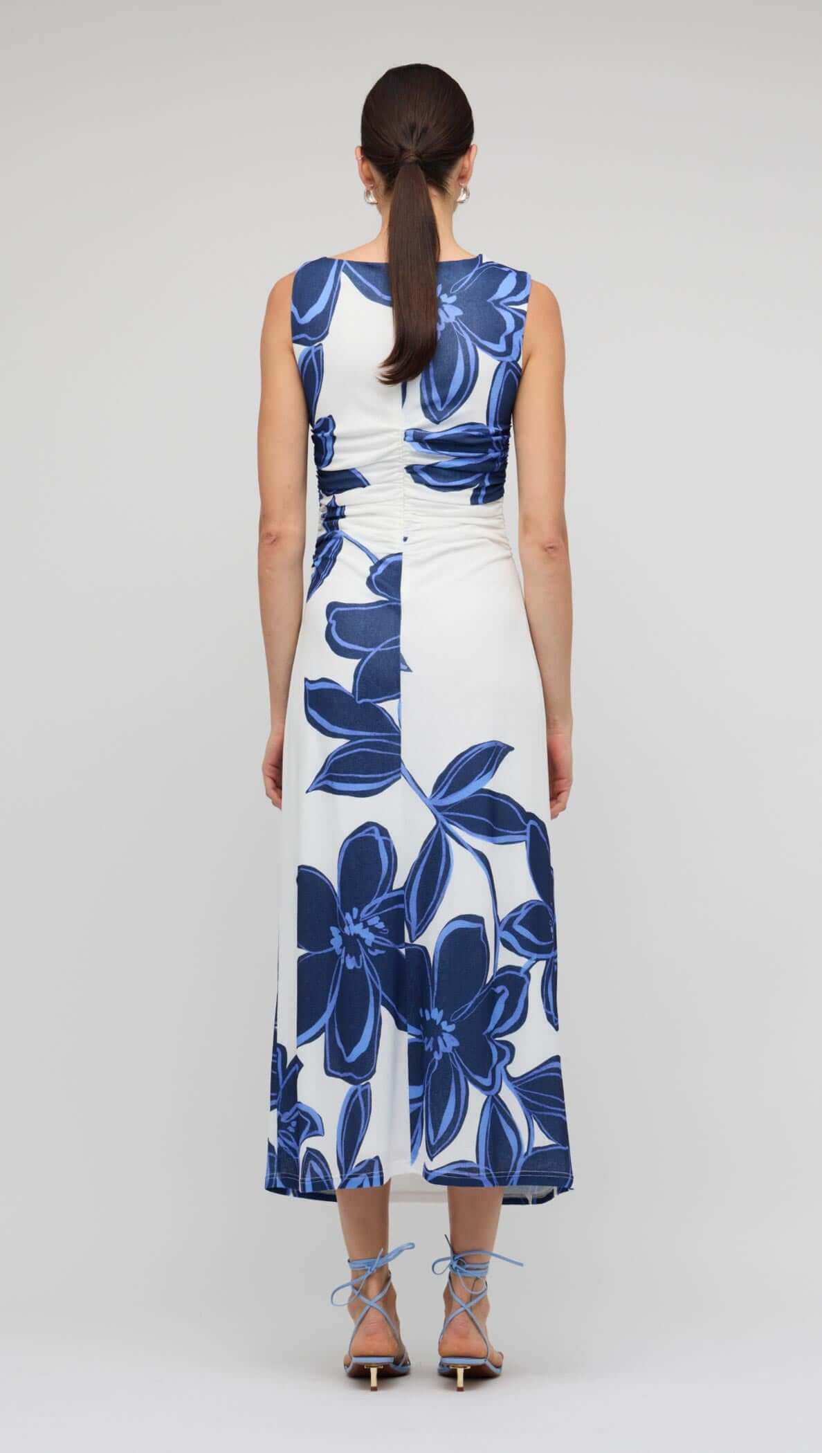 Back view of a model in a Blue & White Floral Mesh Midi Dress showcasing bold floral print and fitted design.