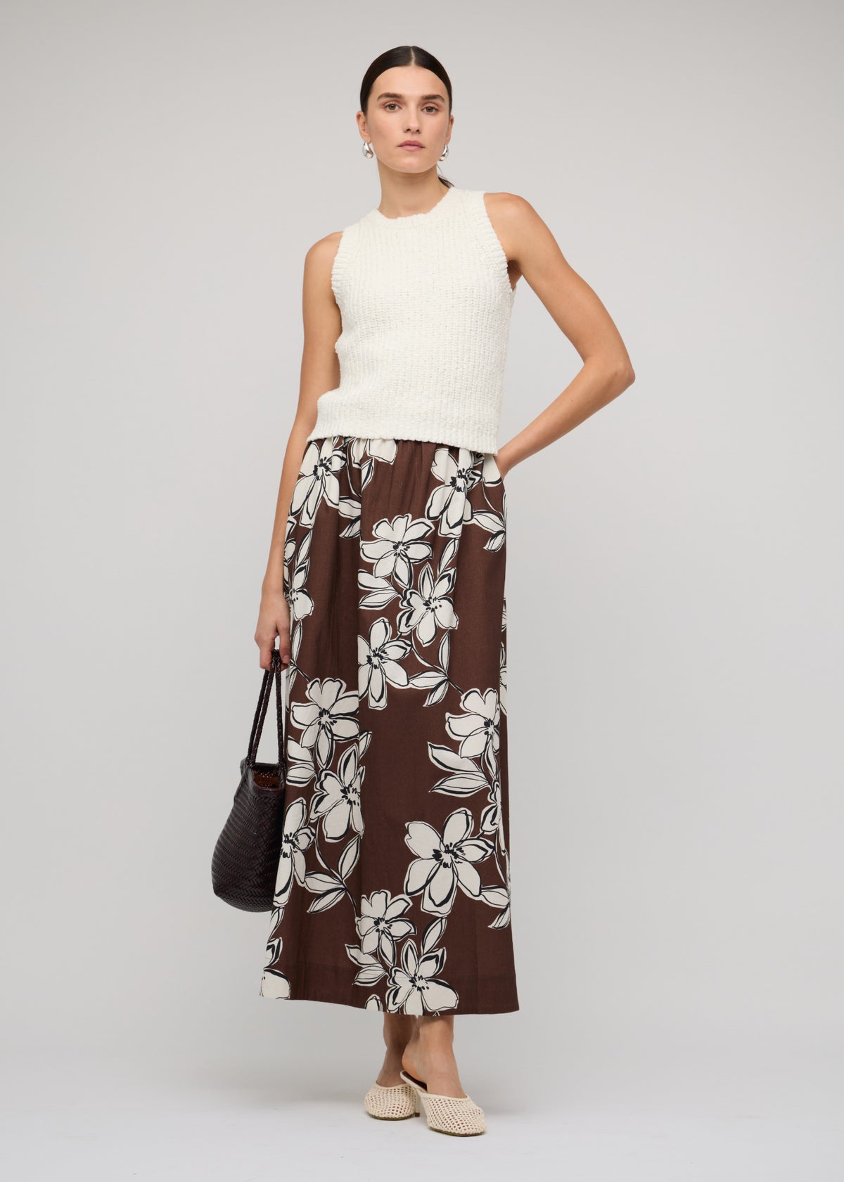Model wearing Brown and White Cotton Floral A-Line Maxi Skirt, showing a maxi length and side seam pockets.