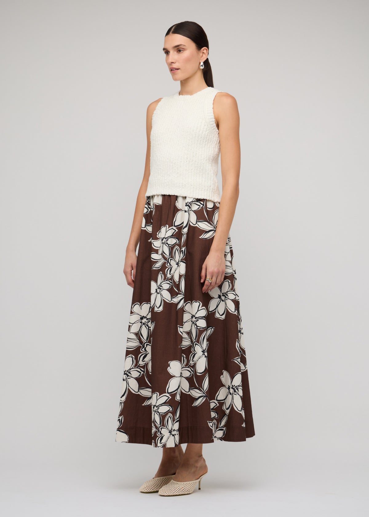 Model wearing Brown and White Cotton Floral A-Line Maxi Skirt with an elasticated waistband and a chocolate brown with white floral print.