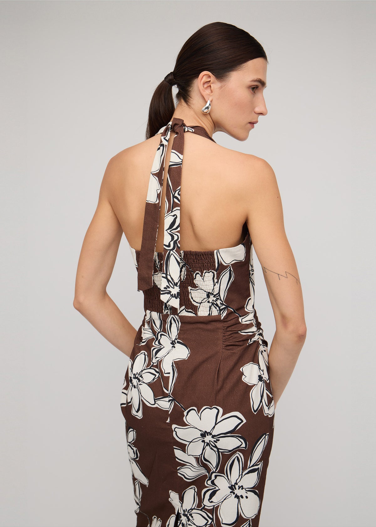 Close-up of Brown and White Cotton Floral Halter-Neck Midi Dress with a chocolate brown with white floral print.