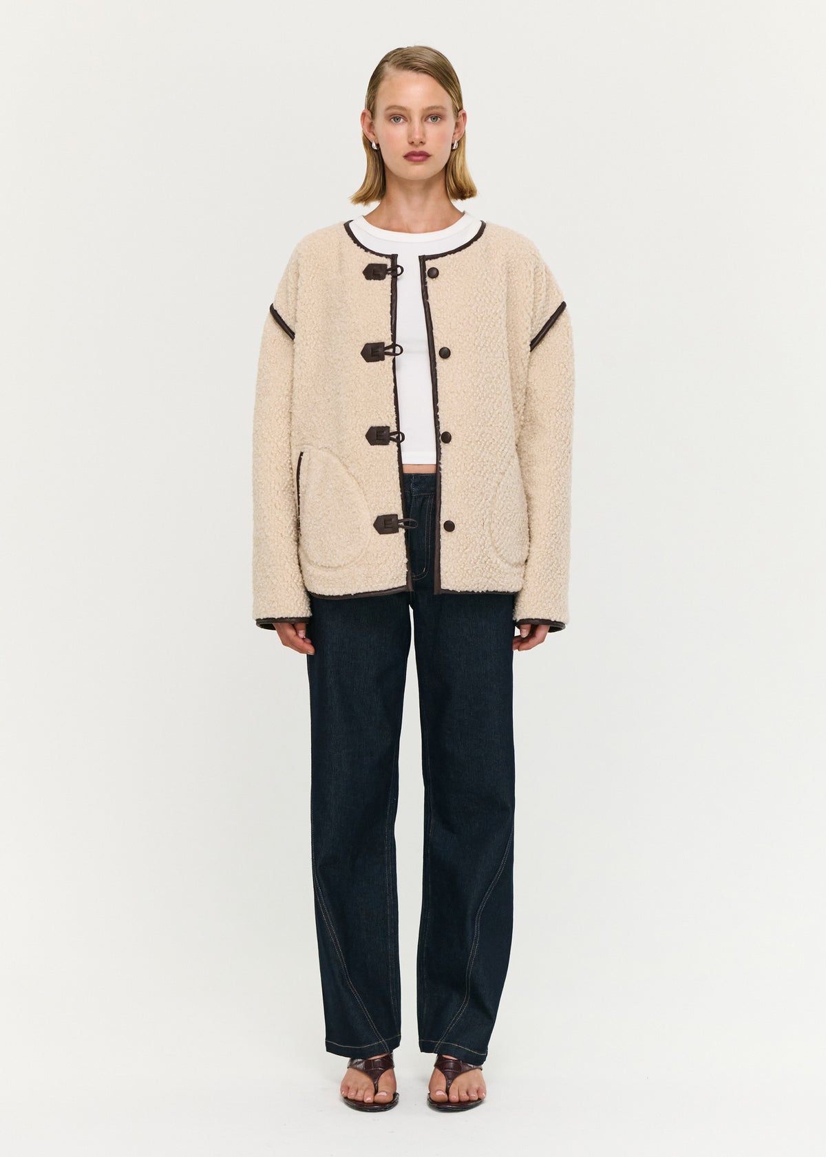 Model wearing Brown Contrast Trim Duffle Coat in Teddy with a collarless neckline and a contrast trim detailing.