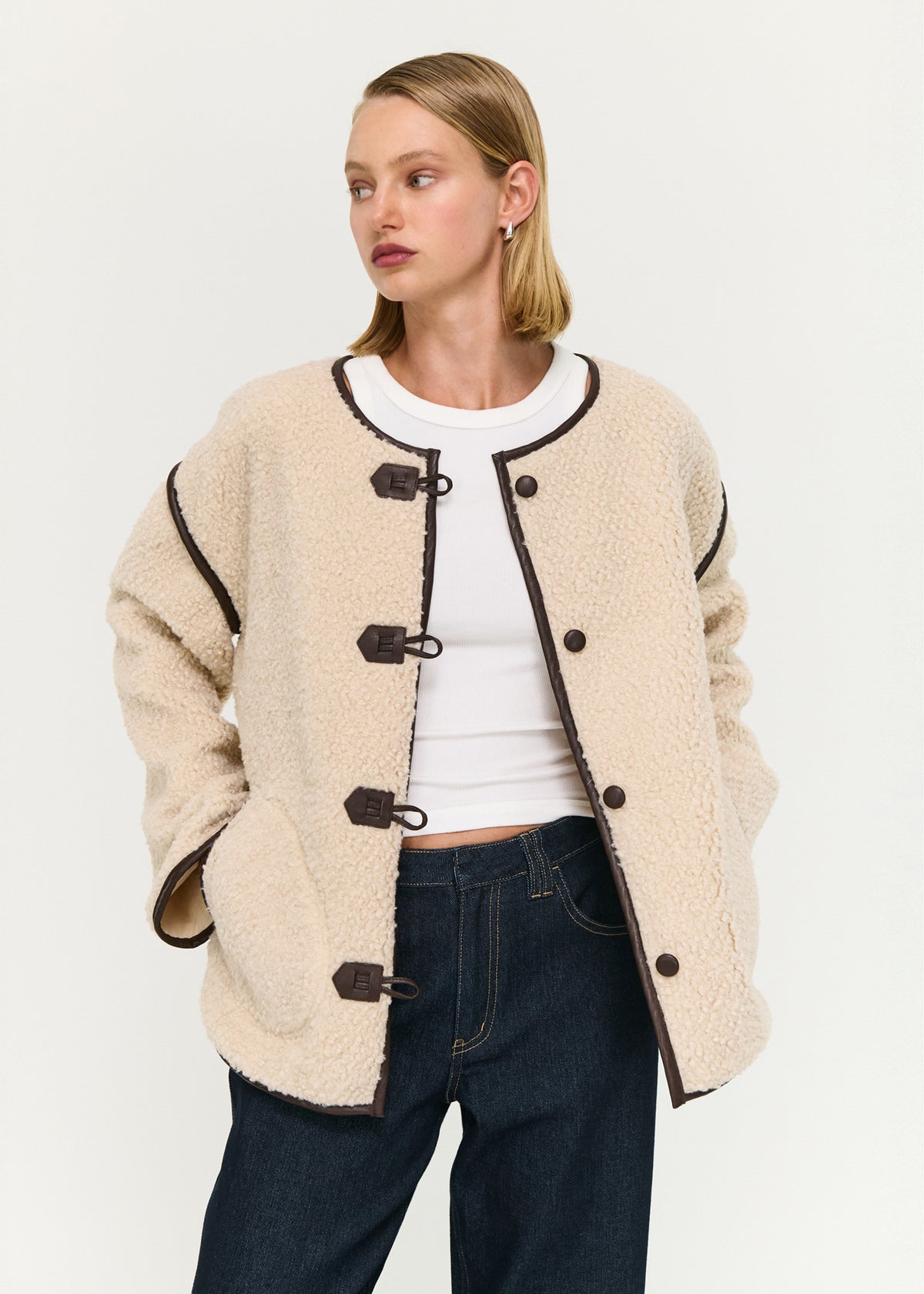 Model wearing Brown Contrast Trim Duffle Coat in Teddy, showing front toggle closures and long sleeves.