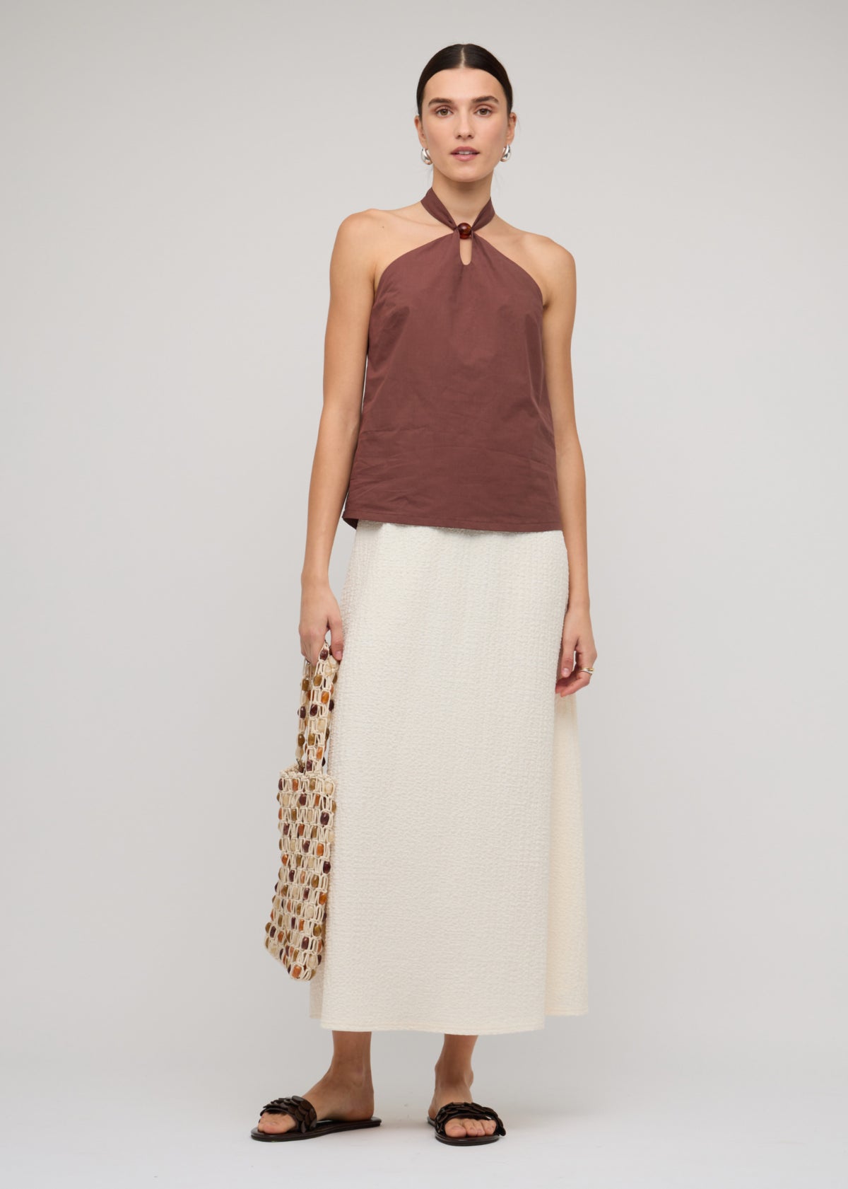 Model wearing Brown Cotton Bead Halter-Neck Top with a chocolate brown colourway and a straight hemline.