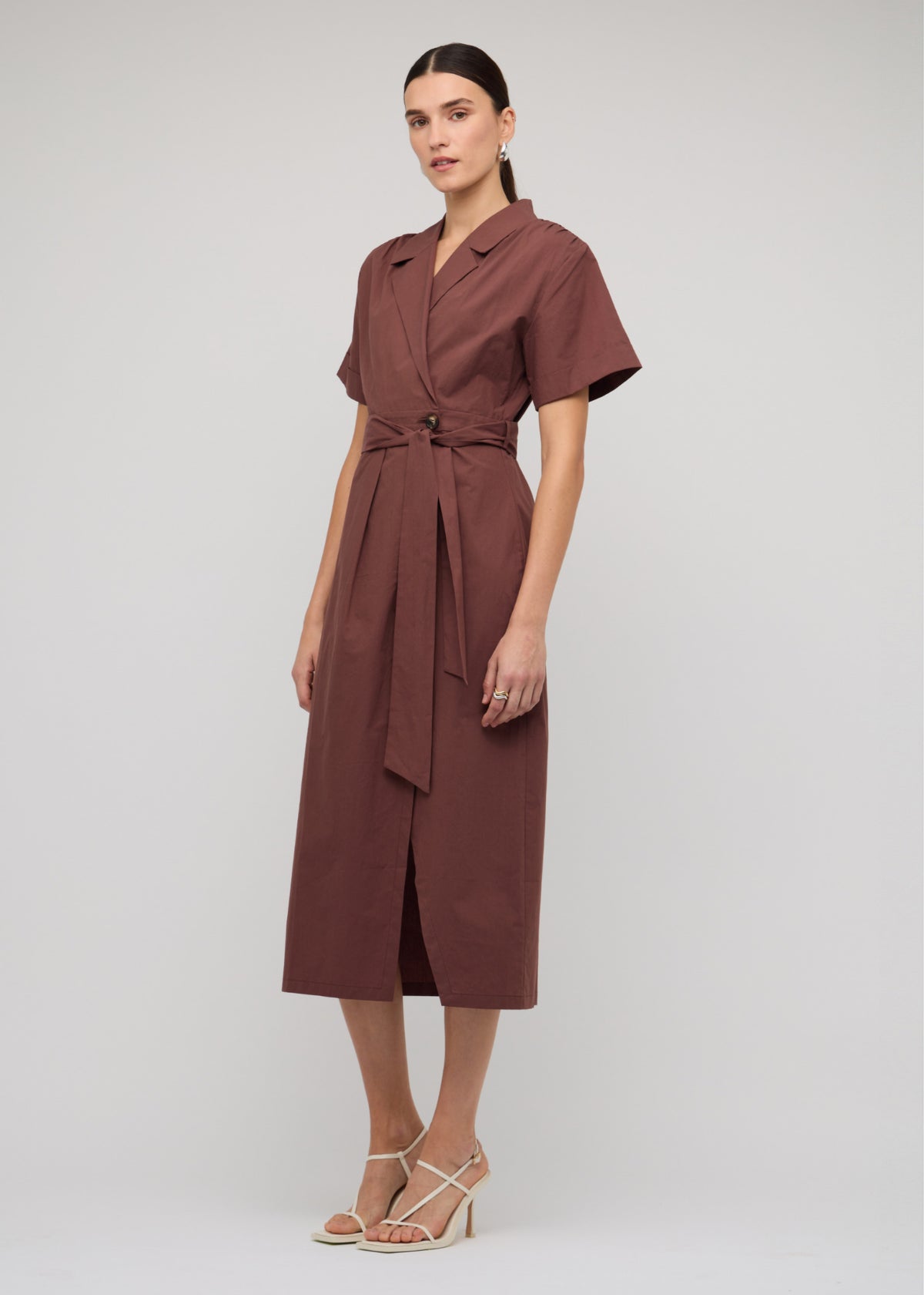 Model wearing Brown Cotton Wrap Midi Shirt Dress with a front split and a 100% Cotton, turned to the side.
