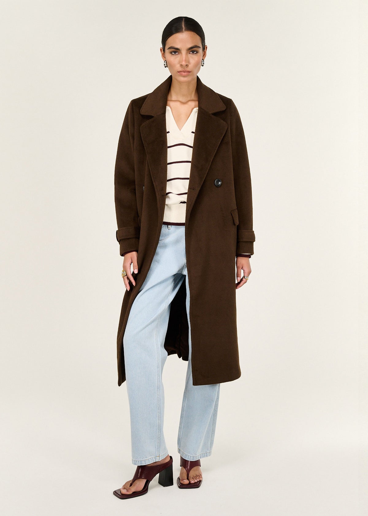 Model wearing Brown Double-Breasted Longline Coat with a soft brushed woven fabrication and a double-breasted front closure.