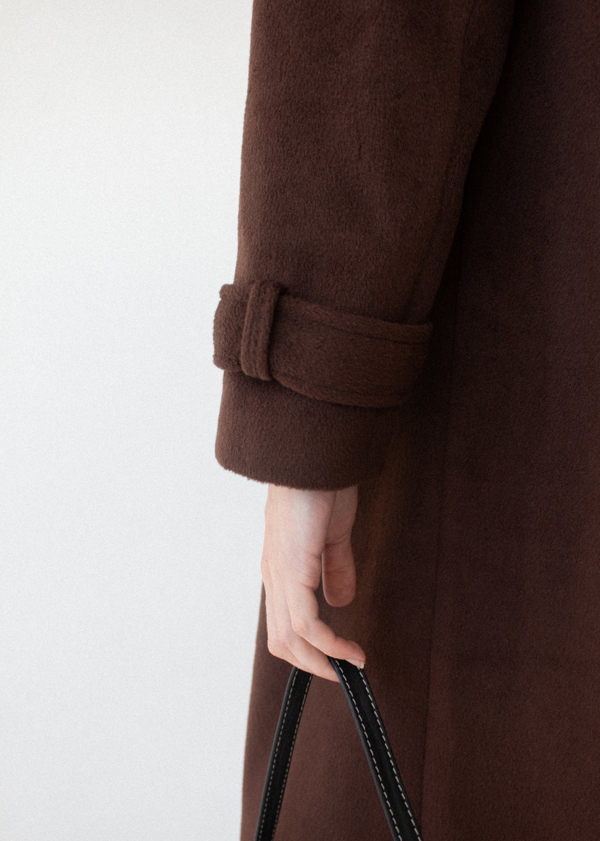 Close-up detail of the Brown Double-Breasted Longline Coat, showing buckled cuff strap.
