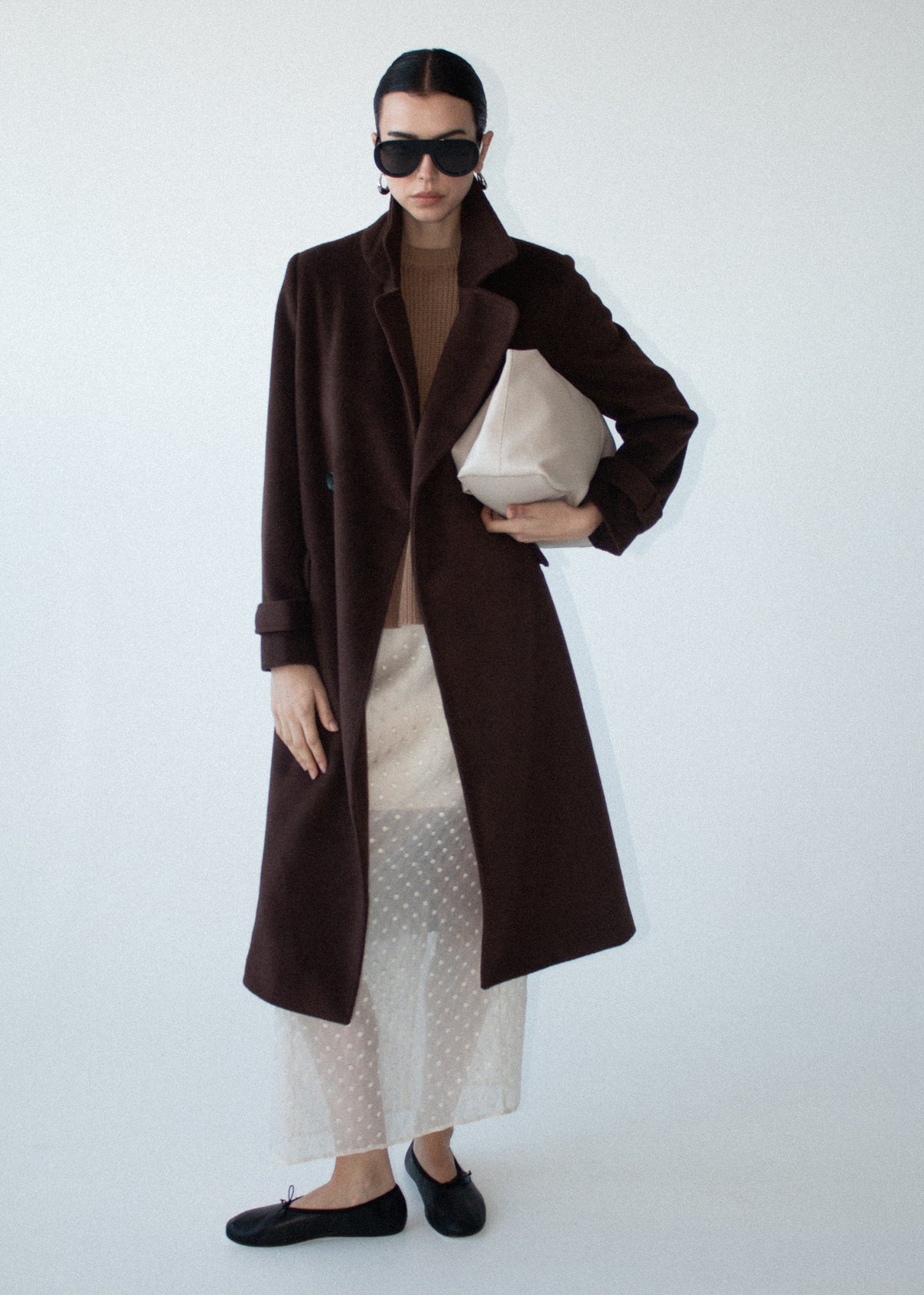 Model wearing Brown Double-Breasted Longline Coat with a structured wide lapel collar and a long sleeves with tab cuff detailing.