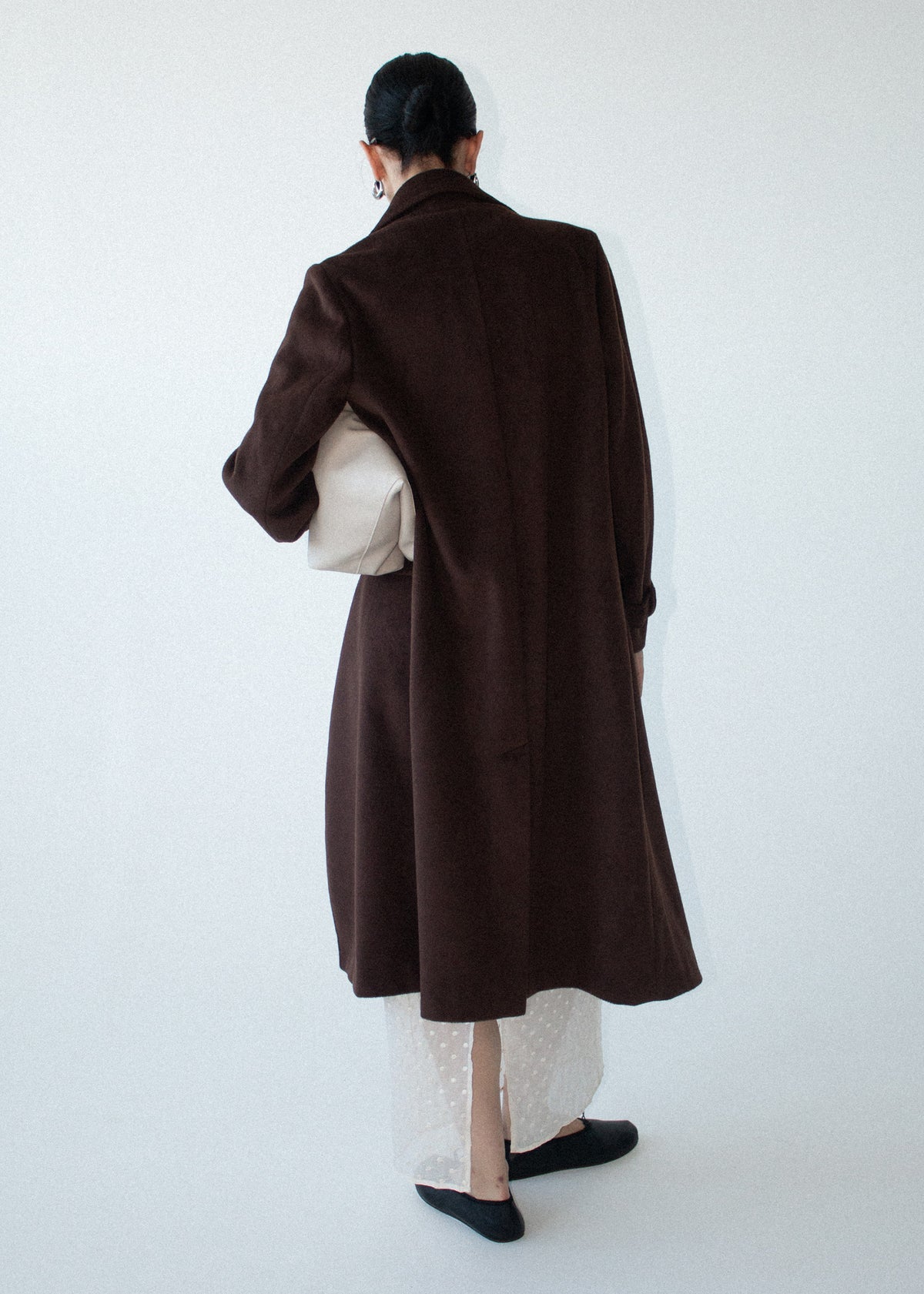 Back view of the Brown Double-Breasted Longline Coat with a back vent and a soft brushed woven fabrication.