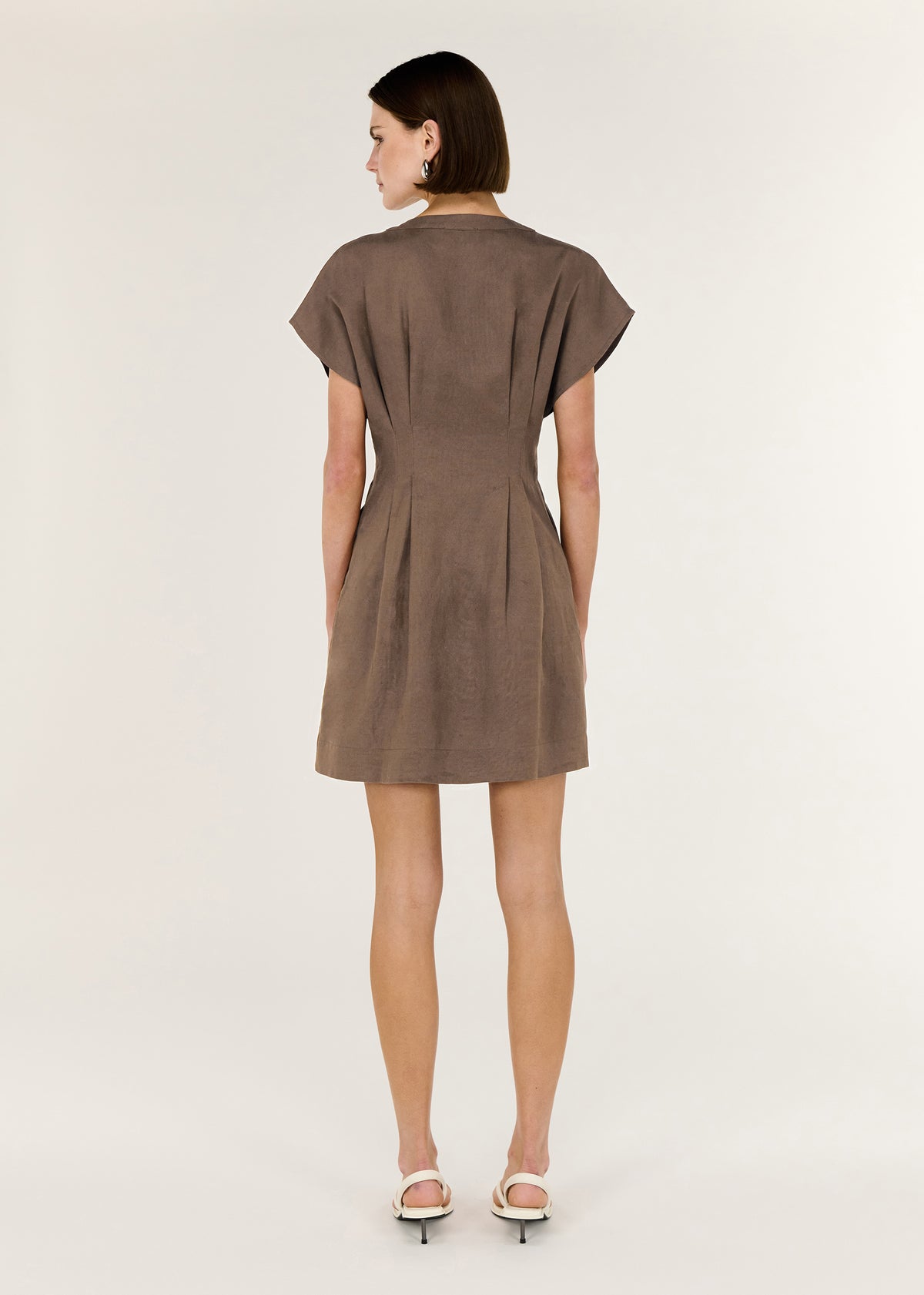 Back view of the Brown Linen Blend Pleated Mini Dress with a tailored silhouette with panel detailing and soft cap sleeves.