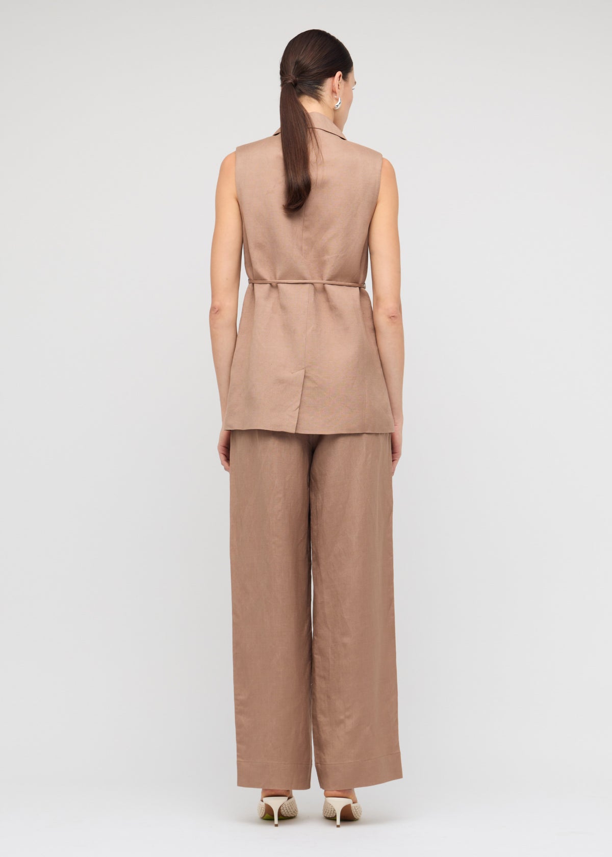 Back view of the Brown Relaxed Wide-Leg Linen Pants with an elastic waistband with drawstring tie and a wide-leg silhouette.