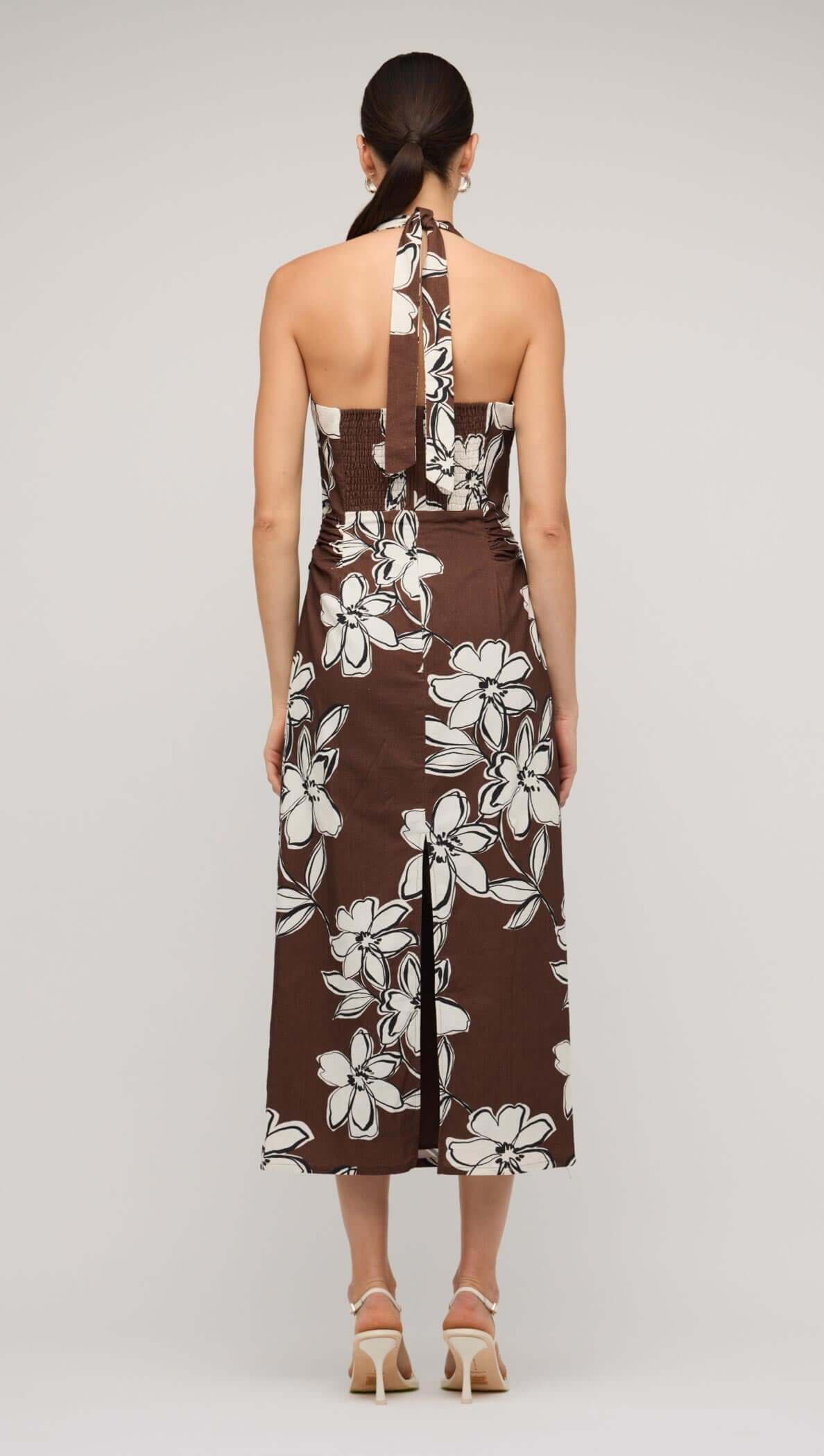 Brown and white floral halter-neck midi dress on model, showcasing elegant design and comfortable fit.