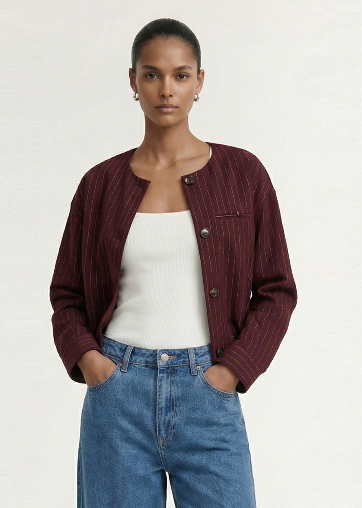 Close-up of the Burgundy Pinstripe Cropped Jacket, showing a collarless neckline and a front button closure.