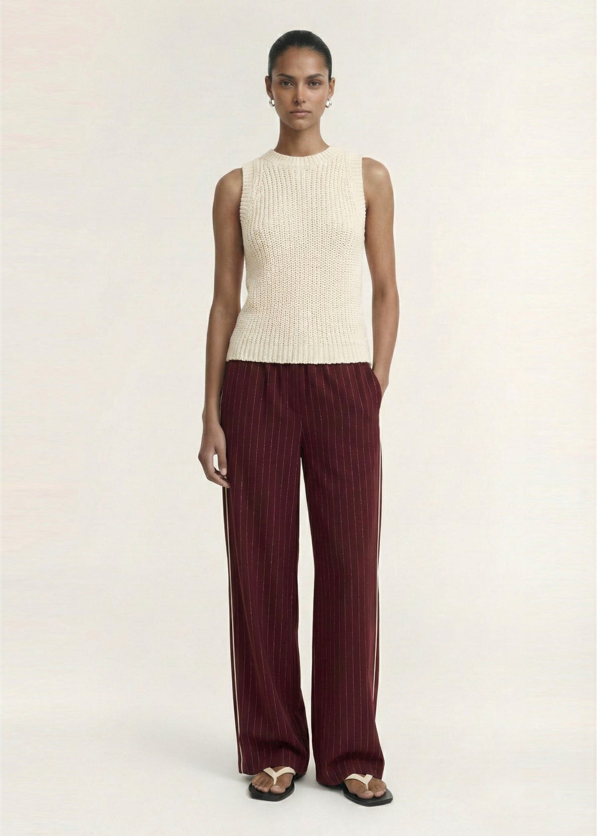 Model wearing Burgundy Pinstripe Relaxed Pant with a soft woven fabrication and a pinstripe design.