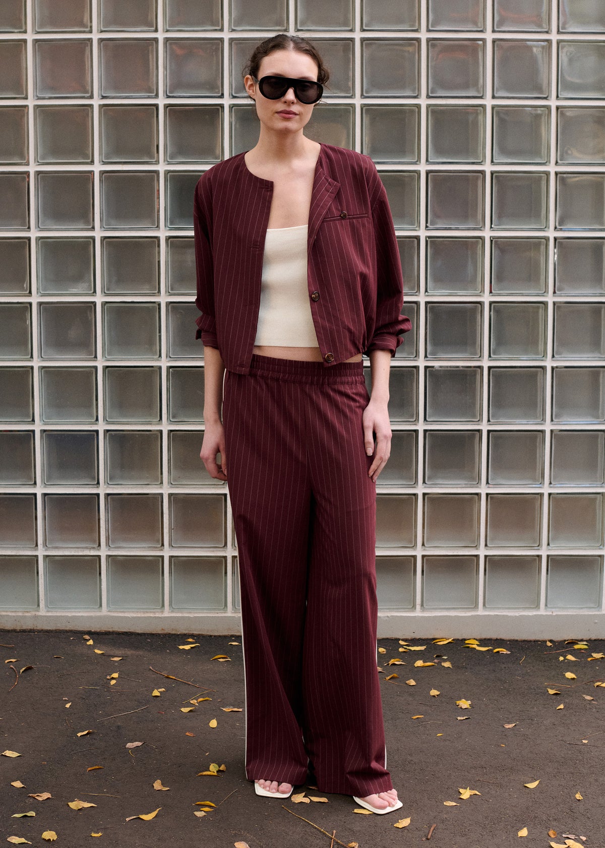 Model wearing Burgundy Pinstripe Relaxed Pant with side seam pockets and a tailored waistband.