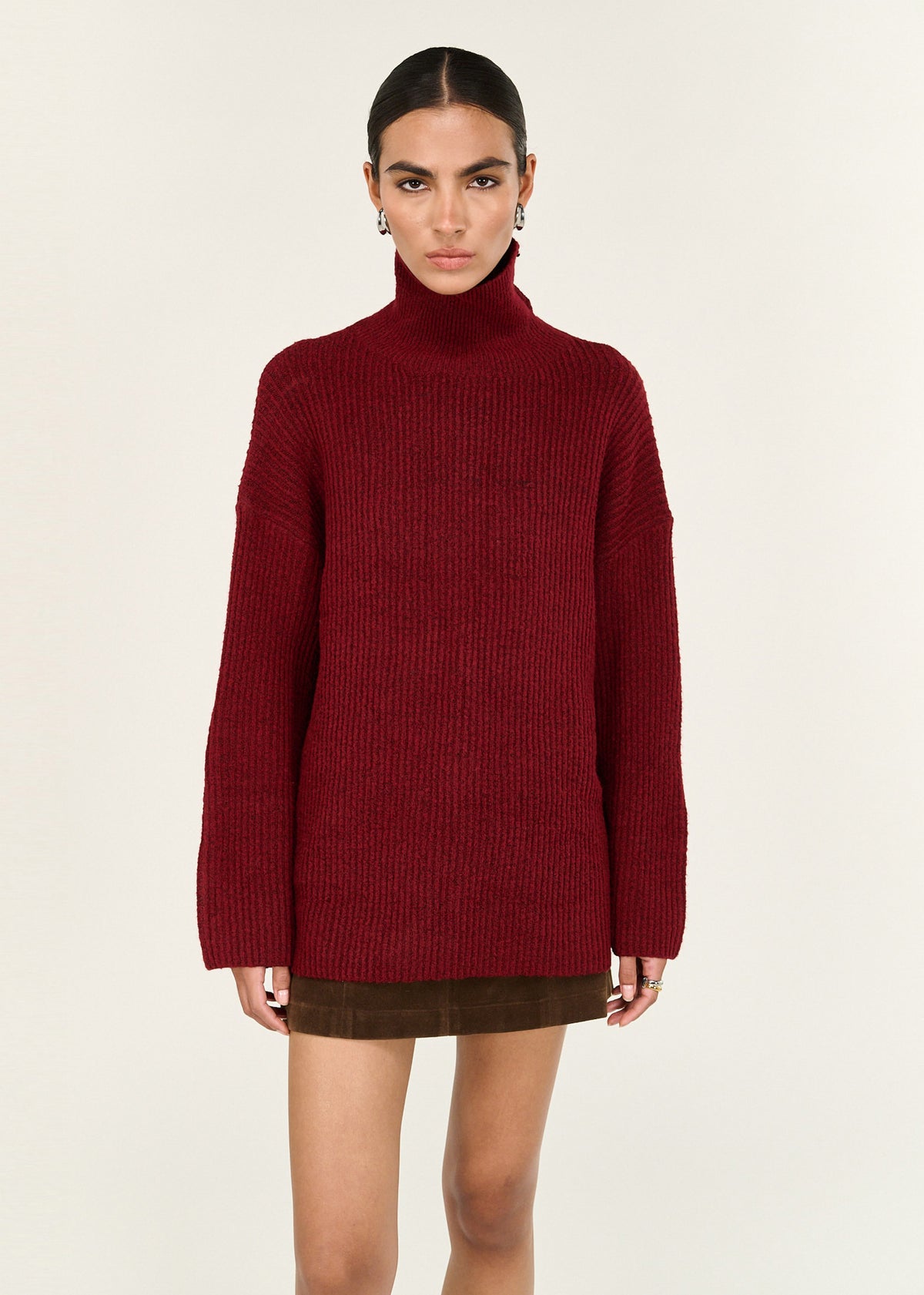 Model wearing Burgundy Roll Neck Oversized Knit Jumper with a roll neck neckline and a relaxed fit.