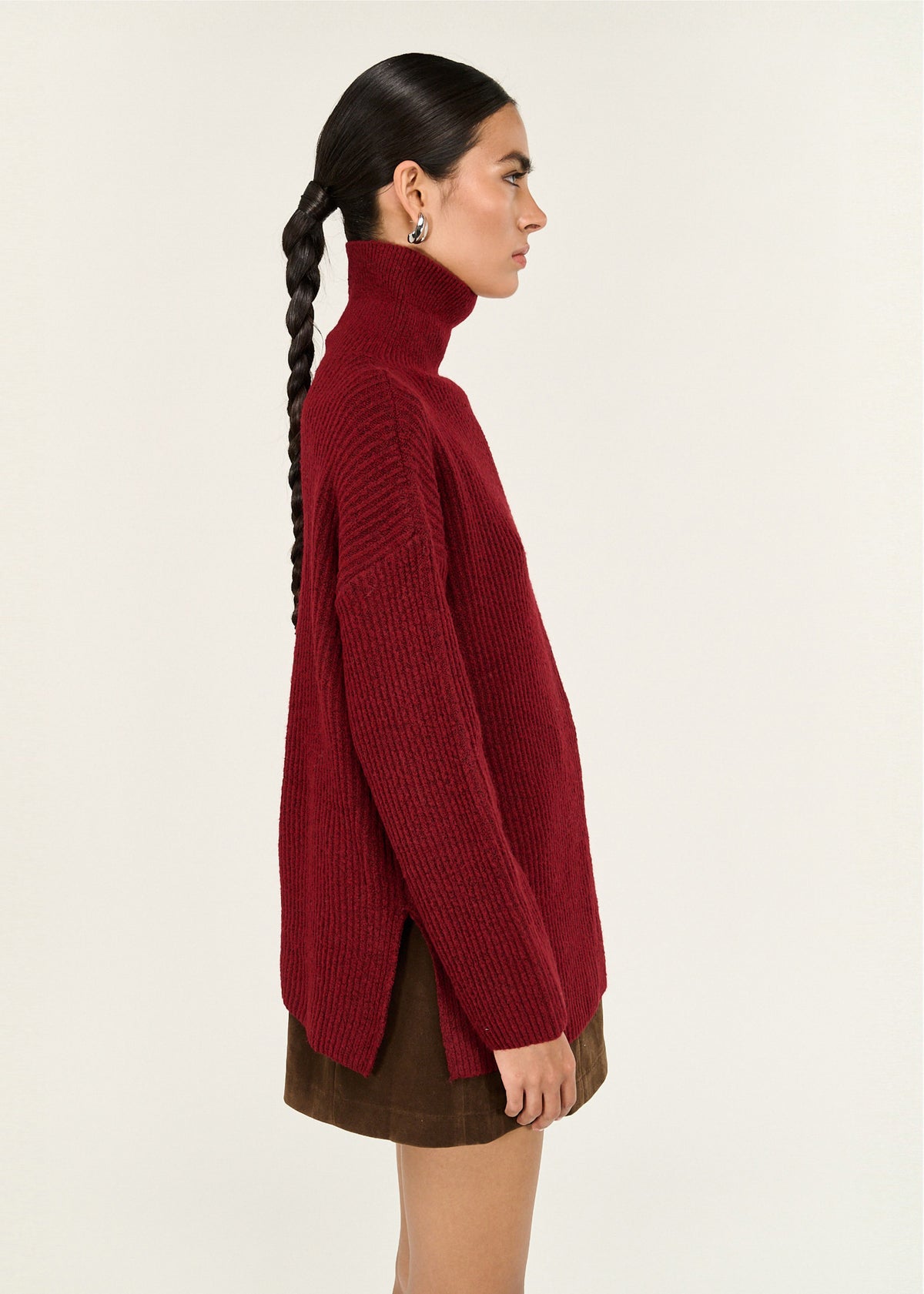 Side view of the Burgundy Roll Neck Oversized Knit Jumper, showing a rich burgundy tone and a soft, warm knit feel.