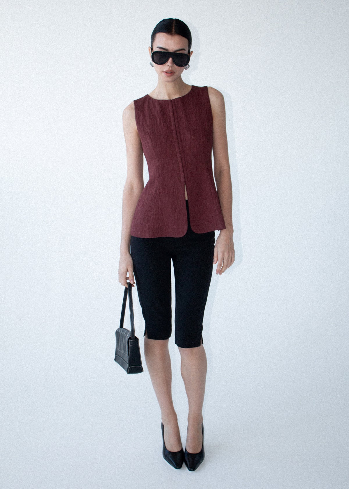 Model wearing Burgundy Round Neck Textured Vest, showing a designed and a textured woven fabrication.