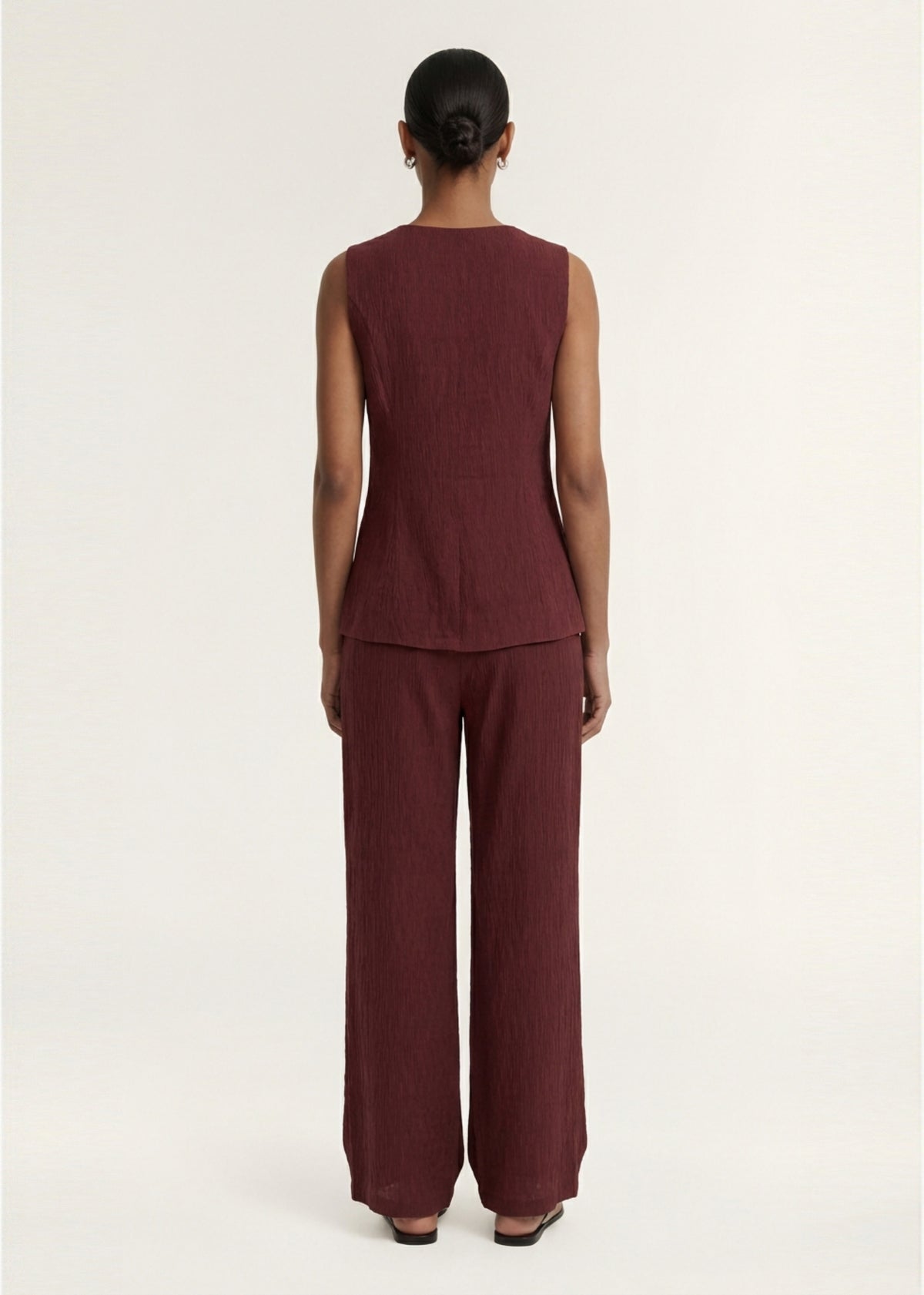 Back view of the Burgundy Round Neck Textured Vest with a textured woven fabrication and a sleeveless silhouette.