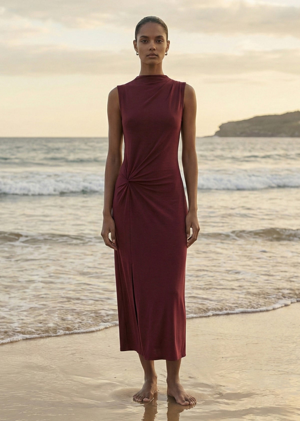 Model wearing Burgundy Twist Detail Jersey Midi Dress with a high neckline and a twist waist detailing, turned to the side.
