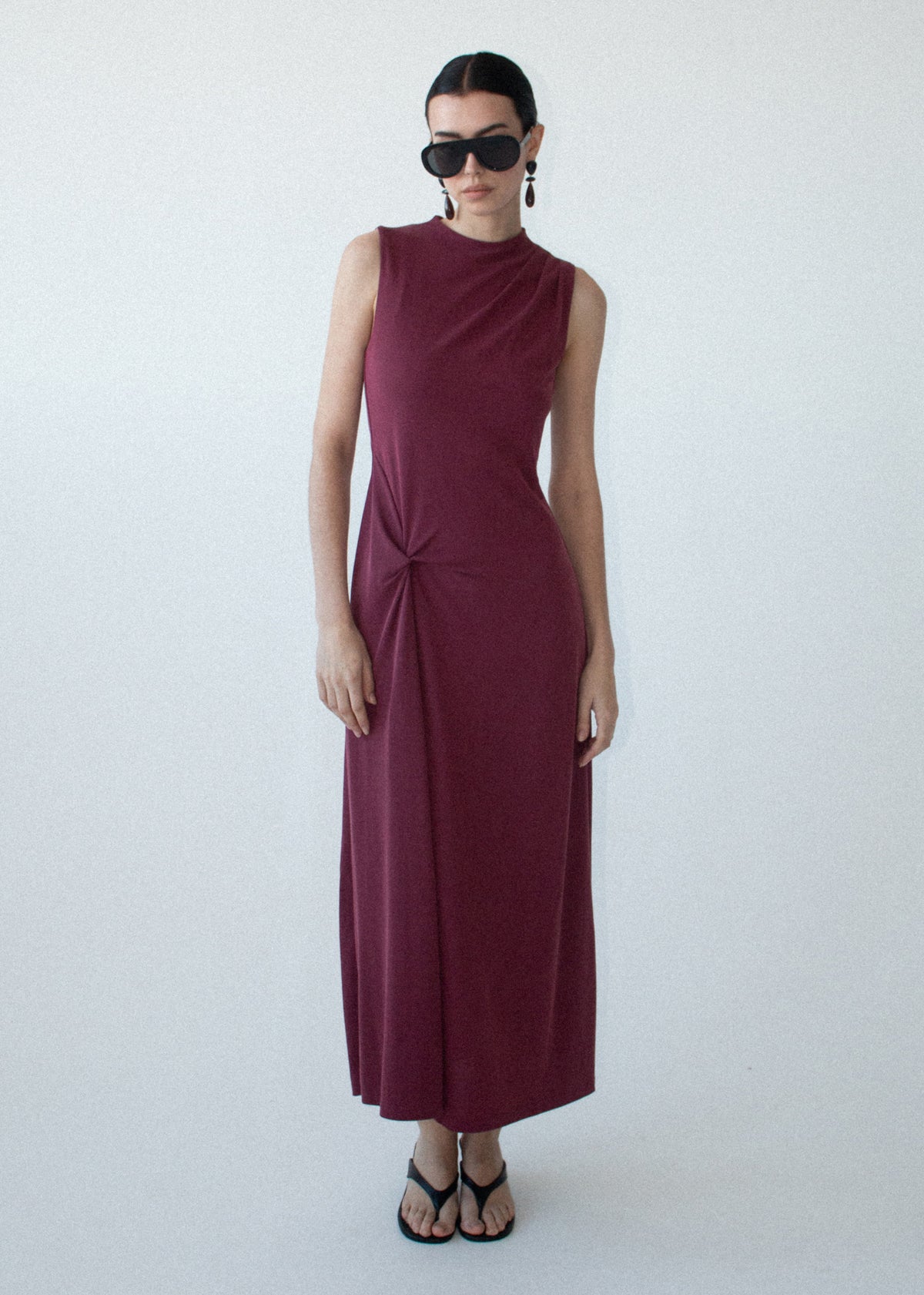 Model wearing Burgundy Twist Detail Jersey Midi Dress, showing a front split feature and a slim fit through bodice.