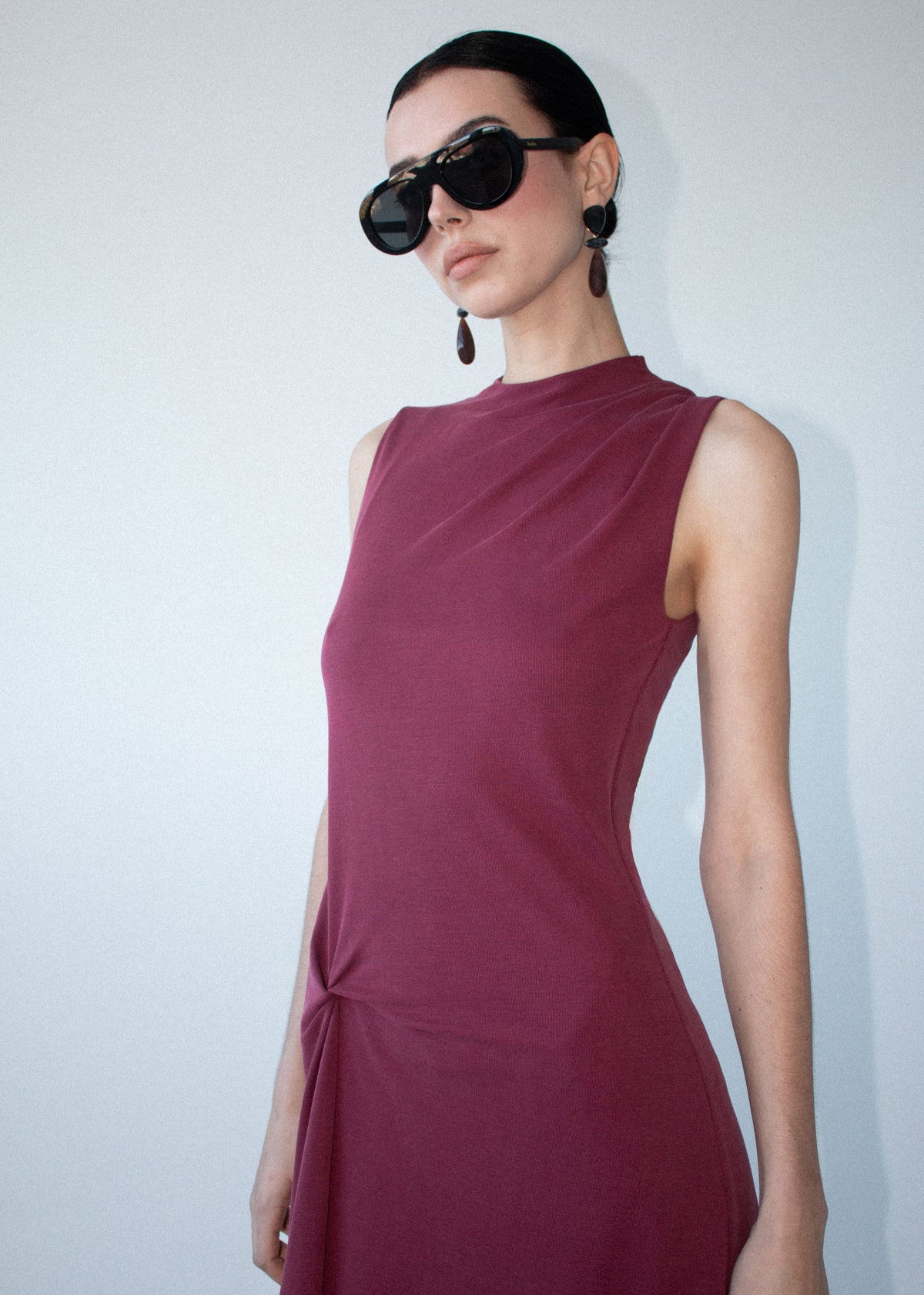 Close-up of the Burgundy Twist Detail Jersey Midi Dress, showing a sleeveless silhouette and a high neckline.
