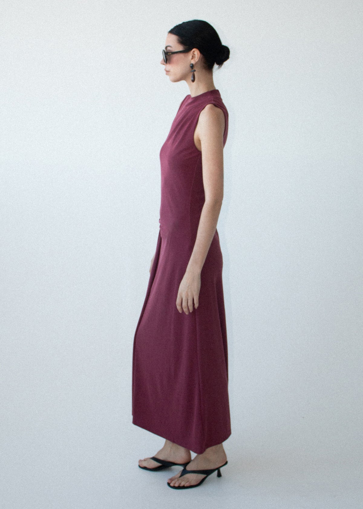 Angled view of the Burgundy Twist Detail Jersey Midi Dress with a sleeveless silhouette and a high neckline.