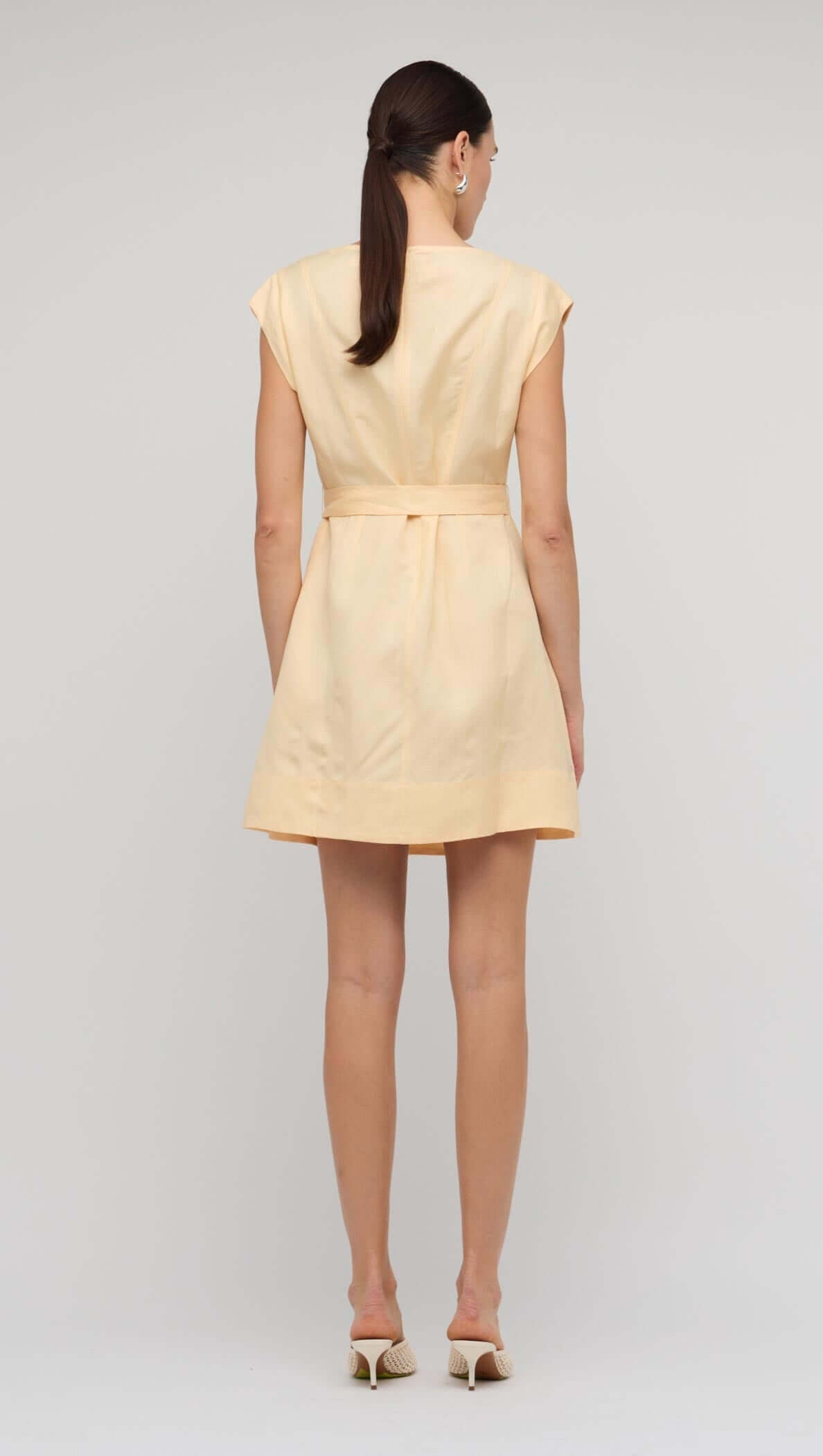 Back view of the Butter Yellow Linen Mini Dress showcasing its relaxed fit and self-tie belt.