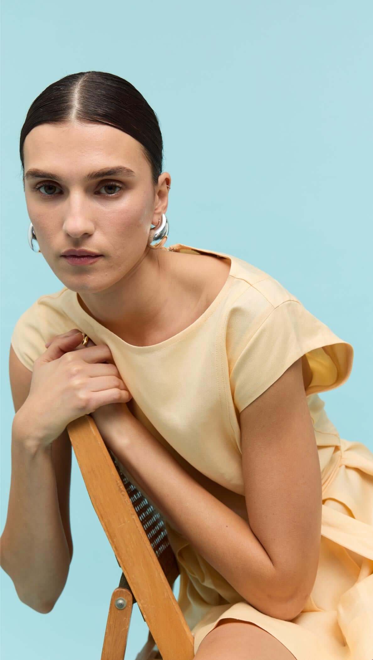 Model wearing a Butter Yellow Linen Mini Dress, showcasing its relaxed neckline and playful design.
