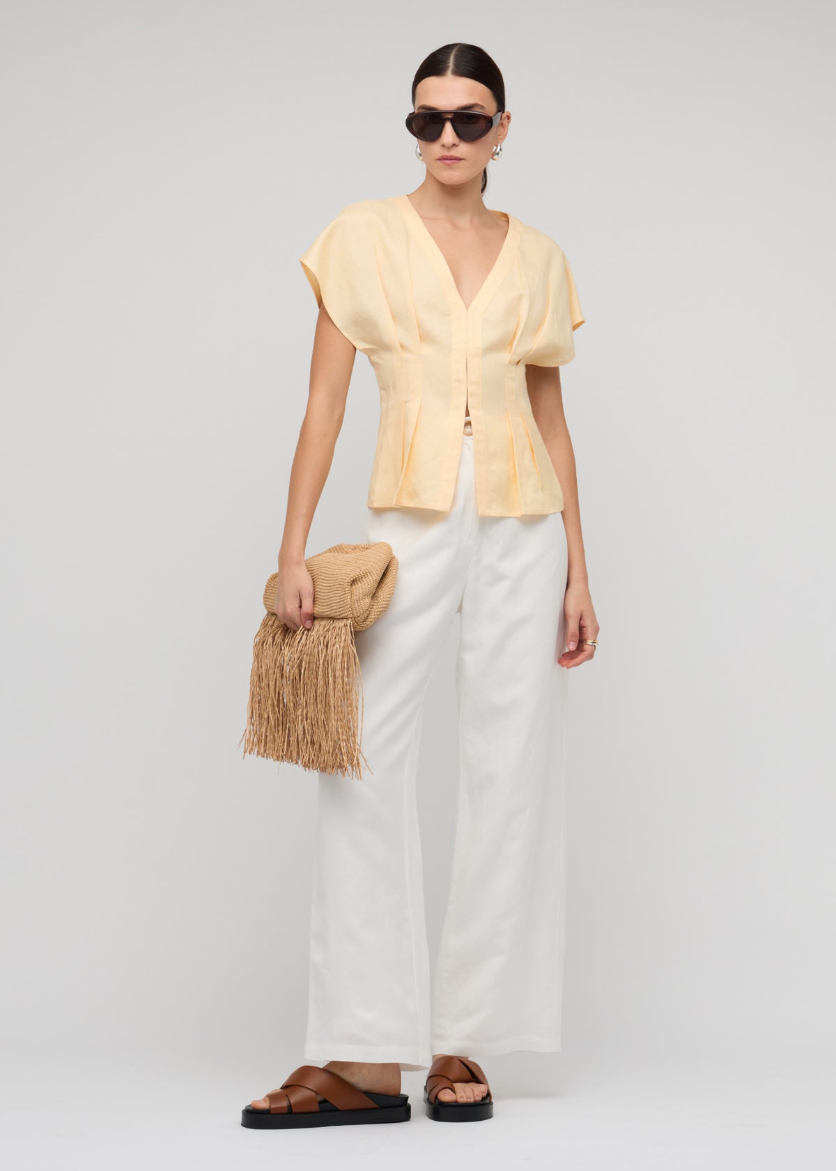 Model wearing Butter Yellow Linen Pleated Blouse with a pleated front detailing and a subtle peplum hem.