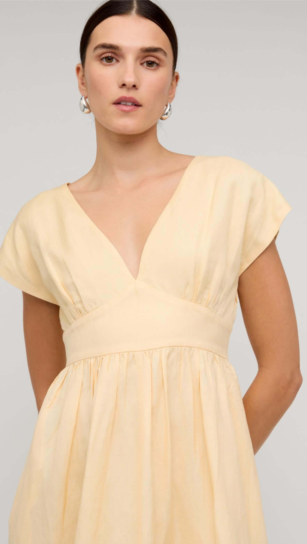 Butter Yellow Linen V-Neck Midi Dress showcasing a soft pastel hue with a deep V-neckline and flowing skirt.