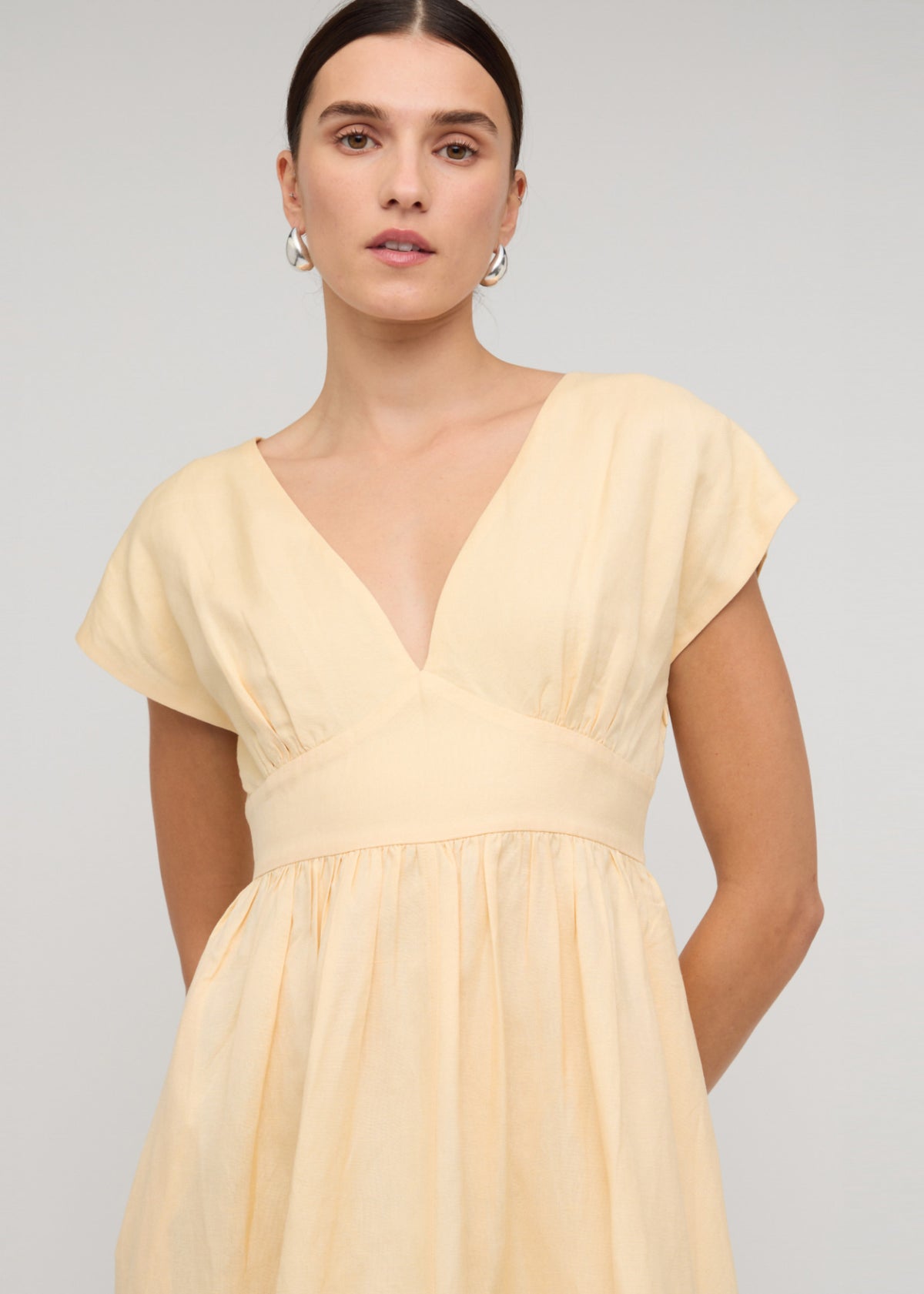 Close-up of the Butter Yellow Linen V-Neck Midi Dress, showing deep V-neckline with cap sleeves.