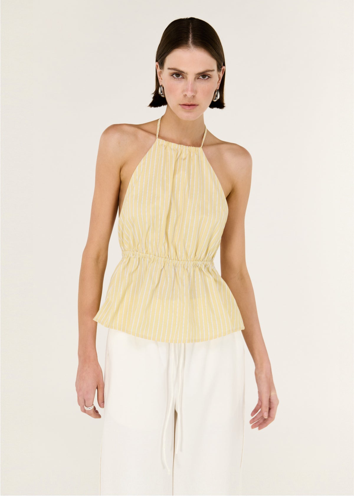 Close-up of the Butter Yellow Low Back Striped Halter Top, showing a halter neckline with adjustable tie and an open back design.