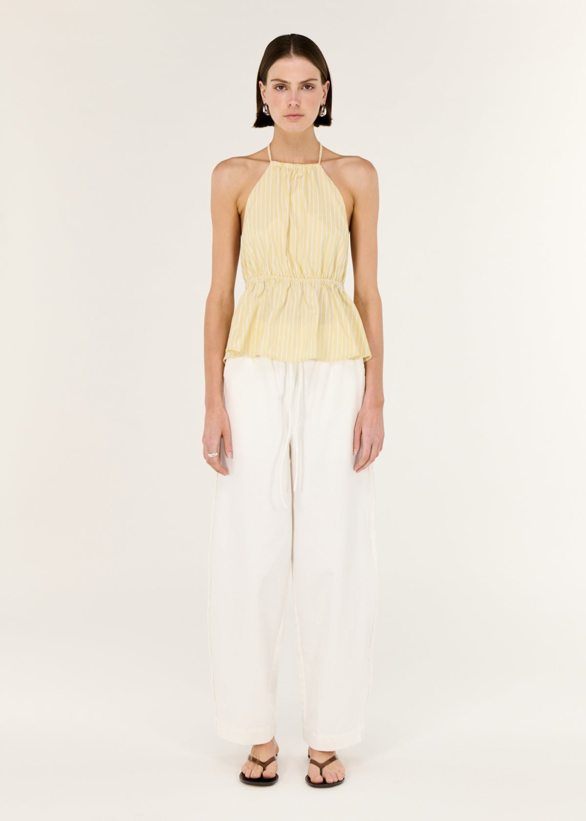 Model wearing Butter Yellow Low Back Striped Halter Top with a softly cinched waist.