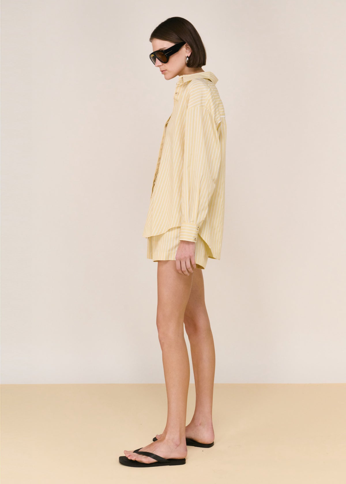 Side view of the Butter Yellow Striped Shorts, showing a yellow and white stripe detailing.