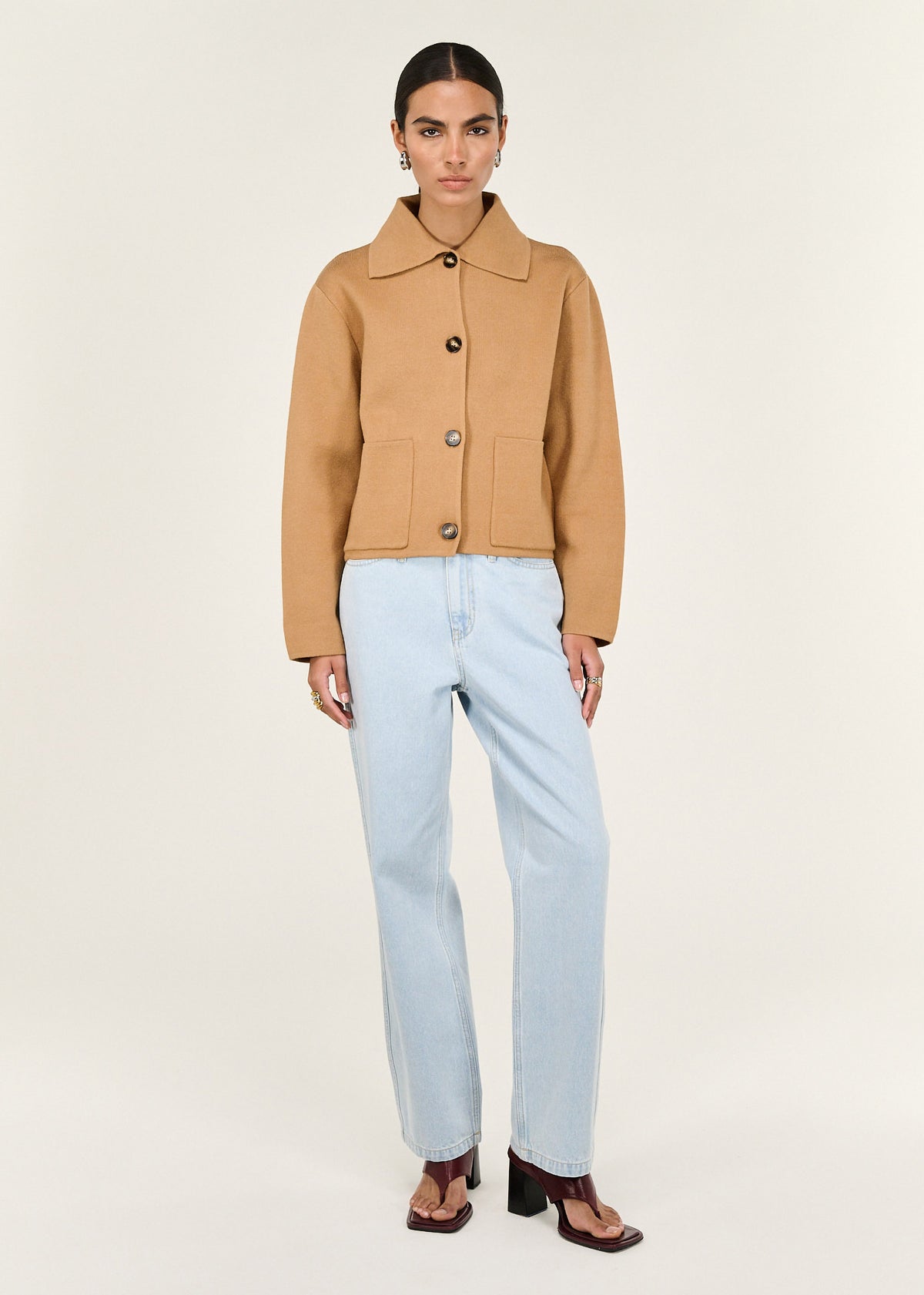 Model wearing Caramel Knitted Barn Jacket, showing a button front closure and front patch pockets.