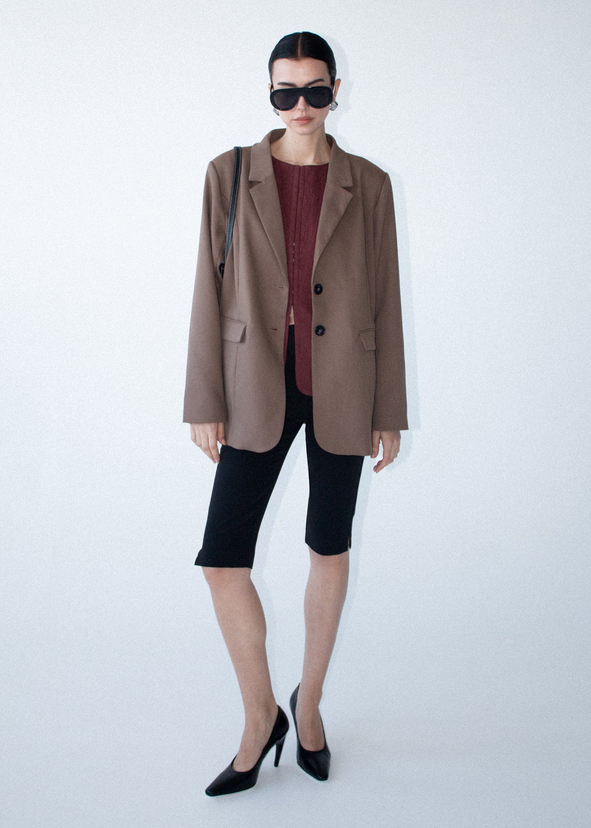 Model wearing Chai Relaxed Tailored Blazer, showing a button cuff detailing and a light khaki colour.