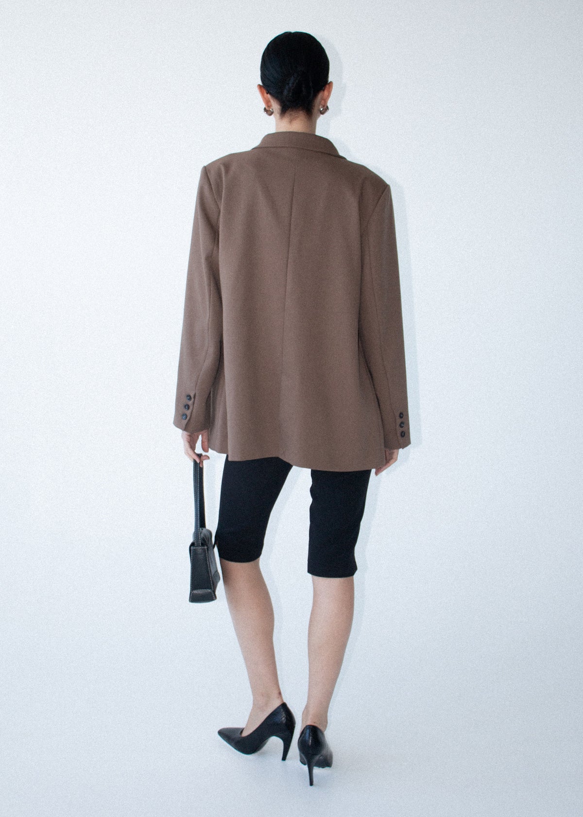 Back view of the Chai Relaxed Tailored Blazer with a button cuff detailing and a relaxed fit.