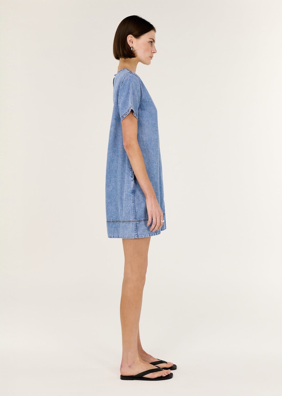 Side view of the Chambray Lightweight Mini Dress, showing a panelled seam detailing and a back keyhole with button closure.