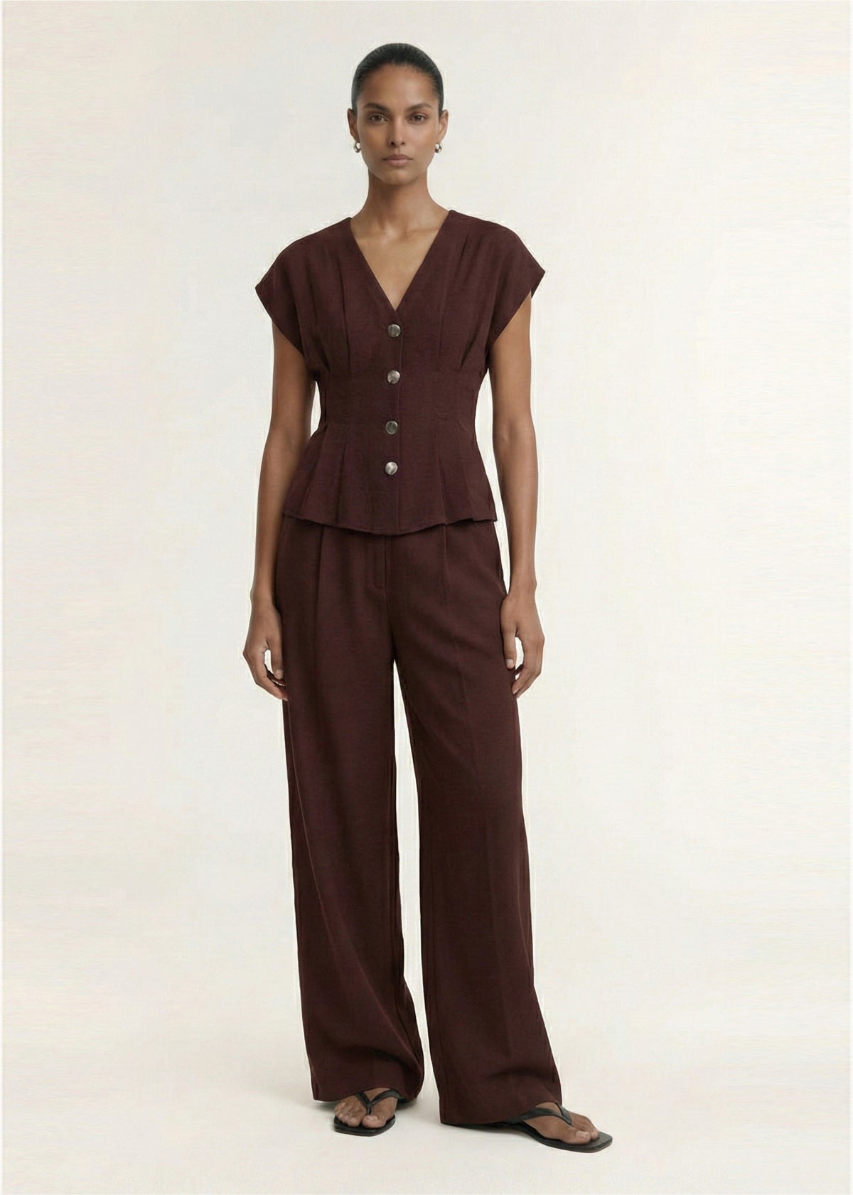 Model wearing Chocolate Linen Blend V-Neck Cropped Top with a lightweight linen fabrication and a plunging V-neckline.